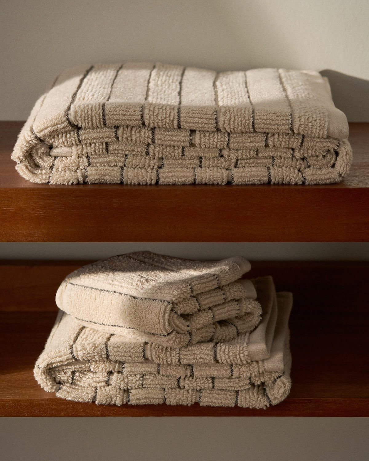 Beiges Handtuch aus 100 % Baumwolle mit Jacquard-Muster in Streifenoptik, rechteckige Form, Grösse 50 x 90 cm.