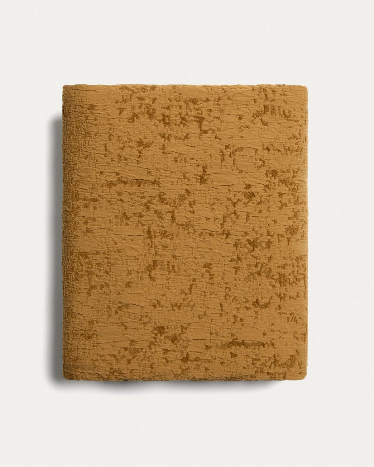 Tagesdecke Sorava von Kave Home in Senfgelb mit Jacquardmuster aus 100 % Baumwolle, drapiert auf einem 150/160-cm-Bett.