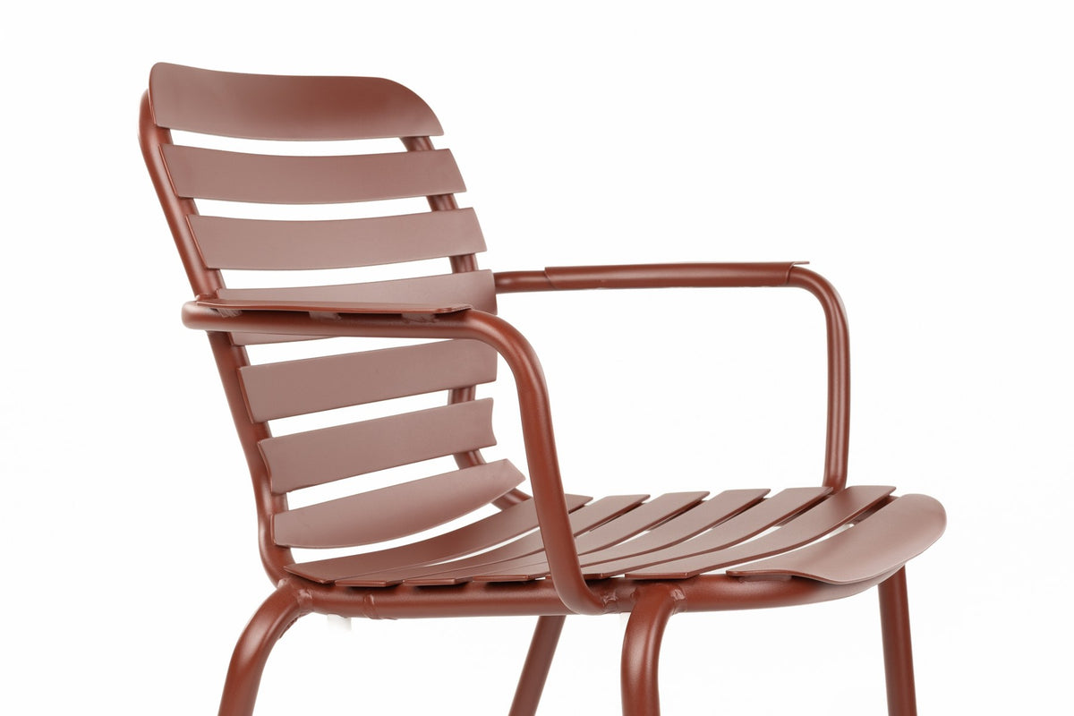 Rotes Gartentischset Vondel von Zuiver: Aluminiumtisch mit offener Struktur und sechs passende Armlehnstühle im Freien.