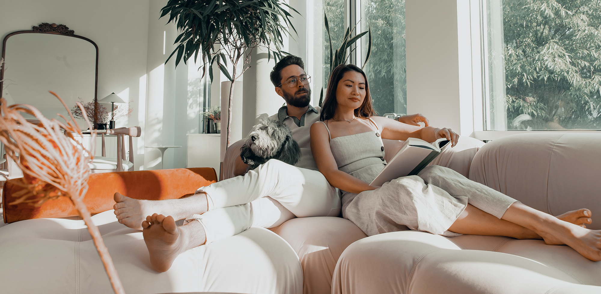 Ehepaar sitzt gemütlich auf weissem Sofa