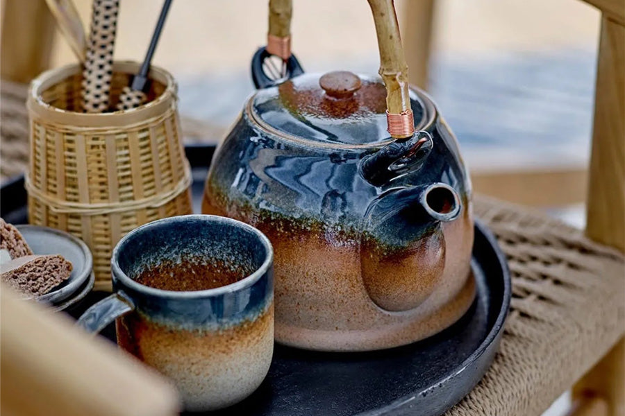 Ein stilvoll arrangiertes Set aus verschiedenen Kaffeetassen, Gläsern und Zubehör auf einem Holztisch, das die Vielfalt und Ästhetik für den perfekten Kaffeegenuss zeigt.