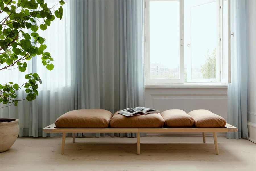 Lounge Around Daybed von Umage – skandinavisches Daybed mit schlankem Eichenholzgestell, gepolstertem Sitz aus Horizons-Stoff, integrierter Tablettablage an der Rückseite, modern und multifunktional.