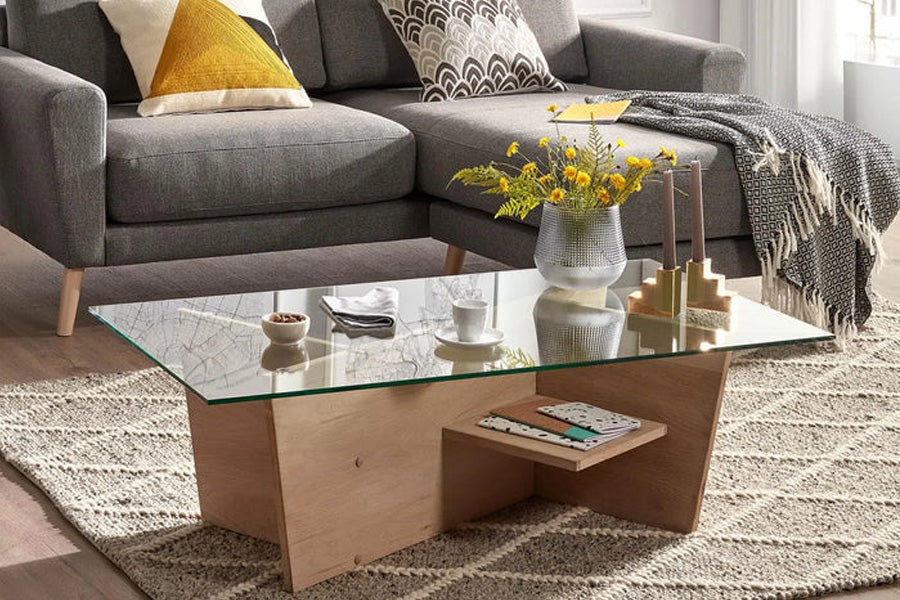 Ein stilvoll eingerichtetes Wohnzimmer mit einem modernen Couchtisch aus Holz und Metall, dekoriert mit einer Vase, Büchern und einer Tasse Kaffee, das eine gemütliche und einladende Atmosphäre schafft.