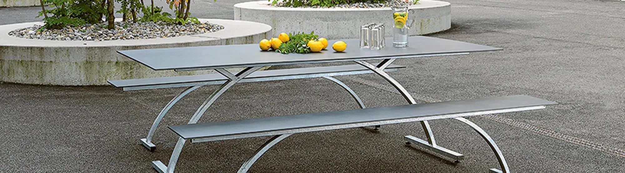 Stilvolle Outdoor-Möbel der Bernardino-Kollektion von Schaffner, gefertigt aus robustem Teakholz und pulverbeschichtetem Aluminium, präsentiert in einer eleganten Gartenszene.
