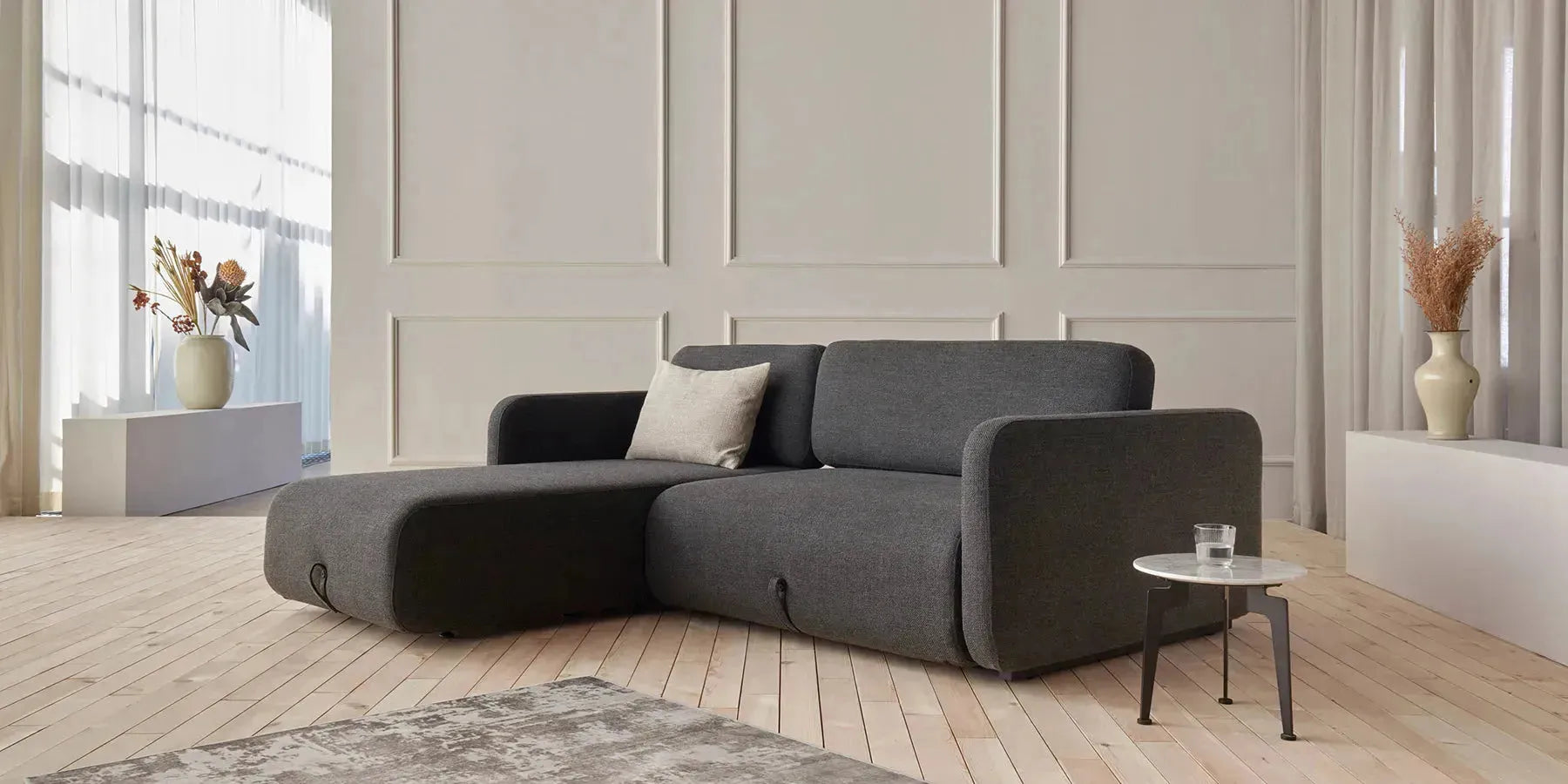 Bettsofa in modernem Design, kombiniert mit stilvoller Einrichtung; multifunktional als Sofa und Schlafplatz nutzbar, ideal für kleine Räume oder Gästezimmer.