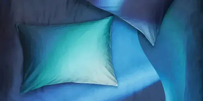 Hochwertige Bettwäsche-Kollektion aus Baumwolle, Satin und Leinen in verschiedenen Designs und Größen, präsentiert in einem stilvoll eingerichteten Schlafzimmer.