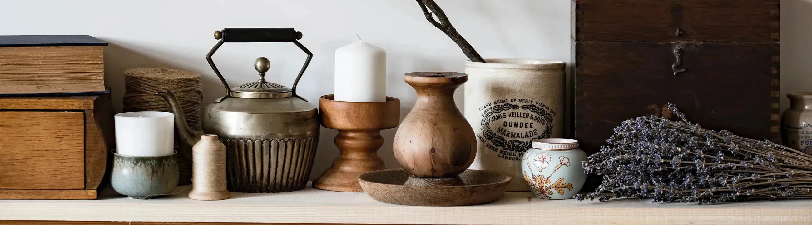 Stilvolle Dekorationsartikel und kreative Wohnaccessoires, darunter Kerzenhalter, Kunstdrucke, Tapeten und Keramikdekorationen, präsentiert in einem modernen und einladenden Ambiente.