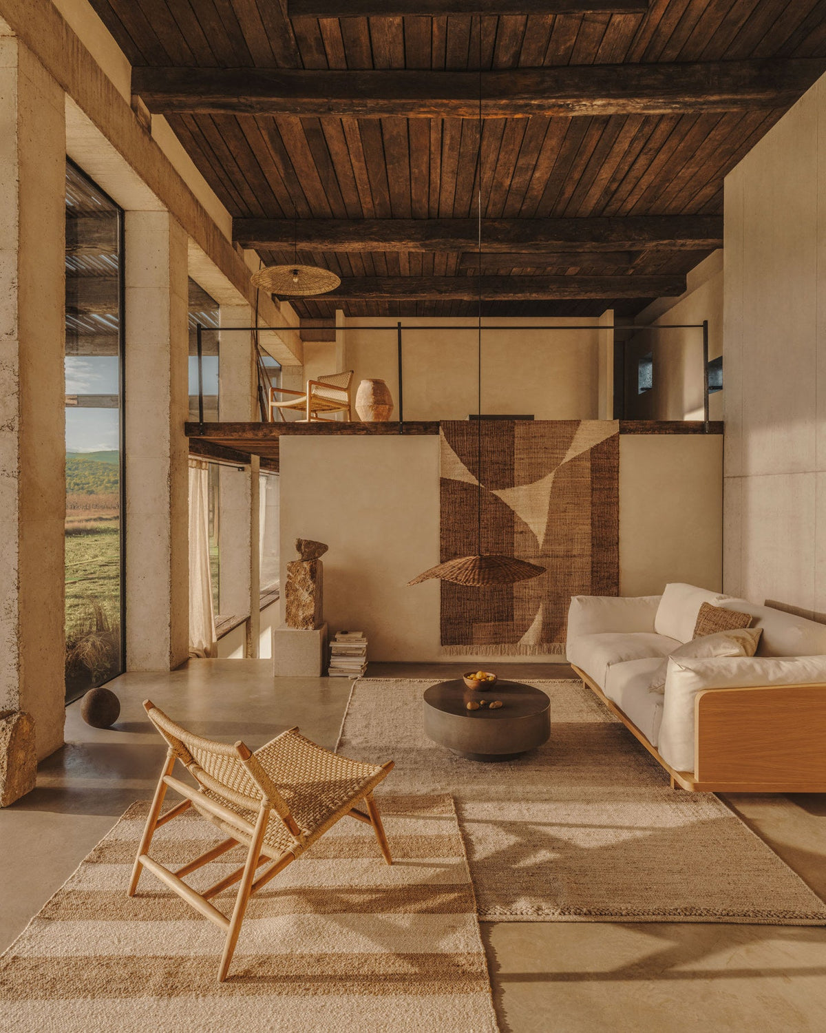 Mediterran einrichten: Wohnzimmer mit Holzbalkendecke, Leinensofa und rundem Couchtisch aus Zement