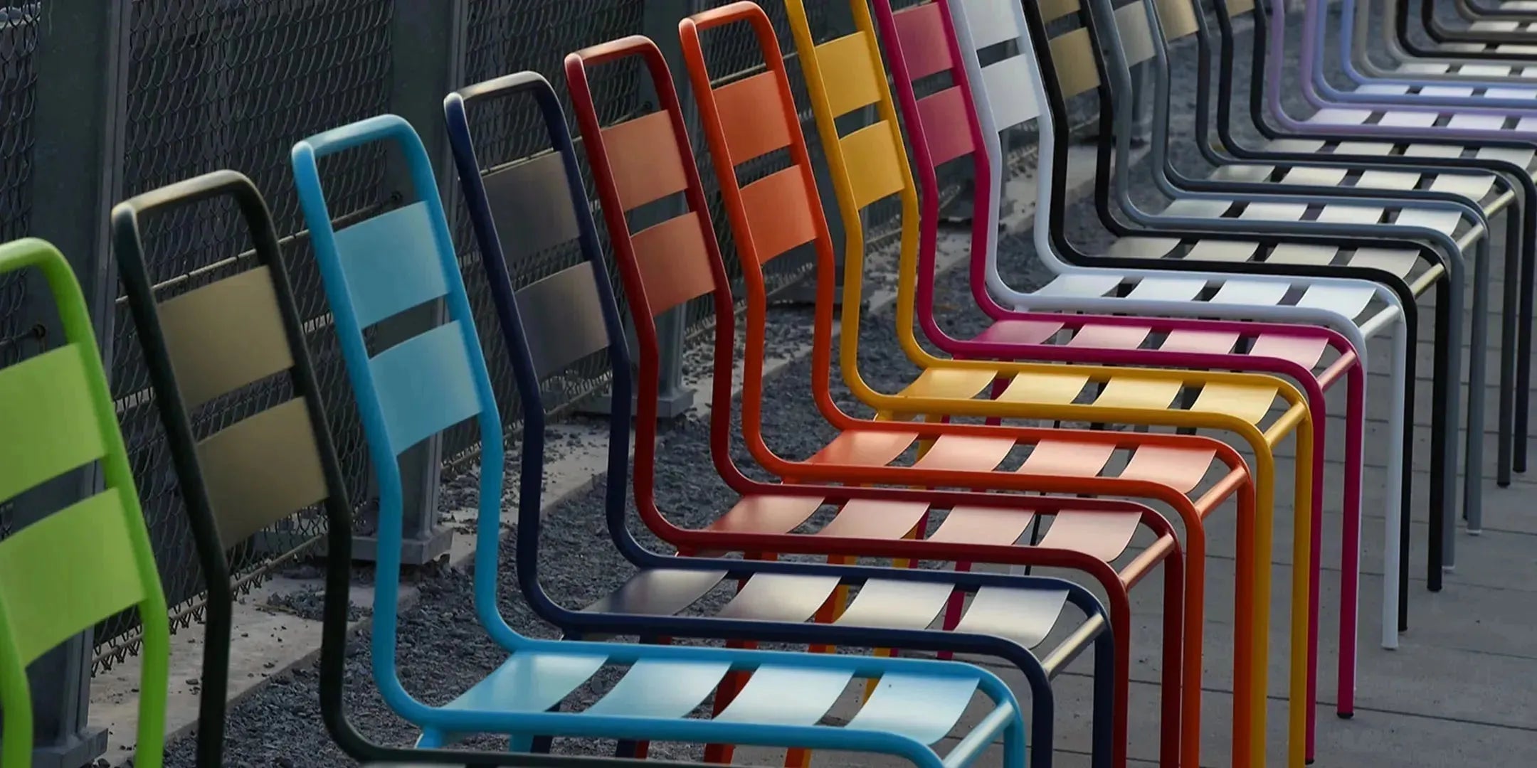 Schaffner Gartenmöbel in verschiedenen Farben auf einer Terrasse, bestehend aus wetterfesten Tischen und Stühlen aus Metall, die langlebige Qualität und stilvolles Design aus der Schweiz vereinen.