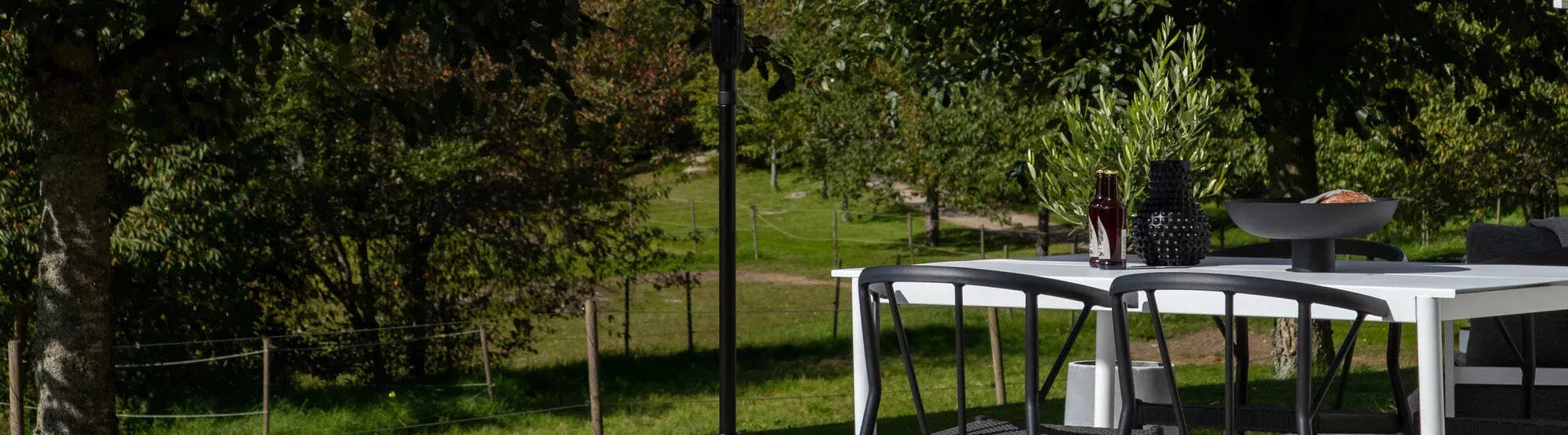 Ausziehbarer Gartentisch auf einer Terrasse, umgeben von stilvollen Gartenstühlen und dekorativen Elementen, ideal für flexible Outdoor-Nutzung.