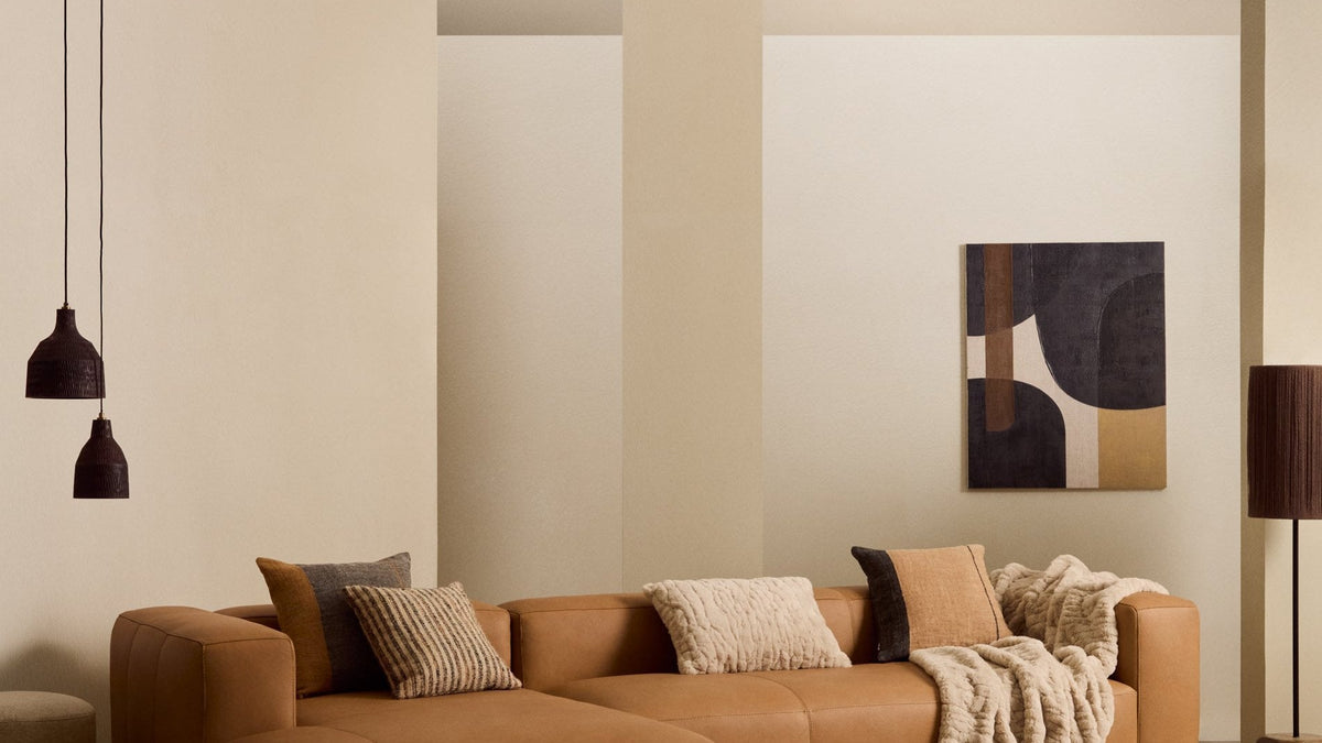 Sofa Blok von Kave Home aus braunem Leder mit Chaiselongue und Lederkissen in einem Wohnzimmer