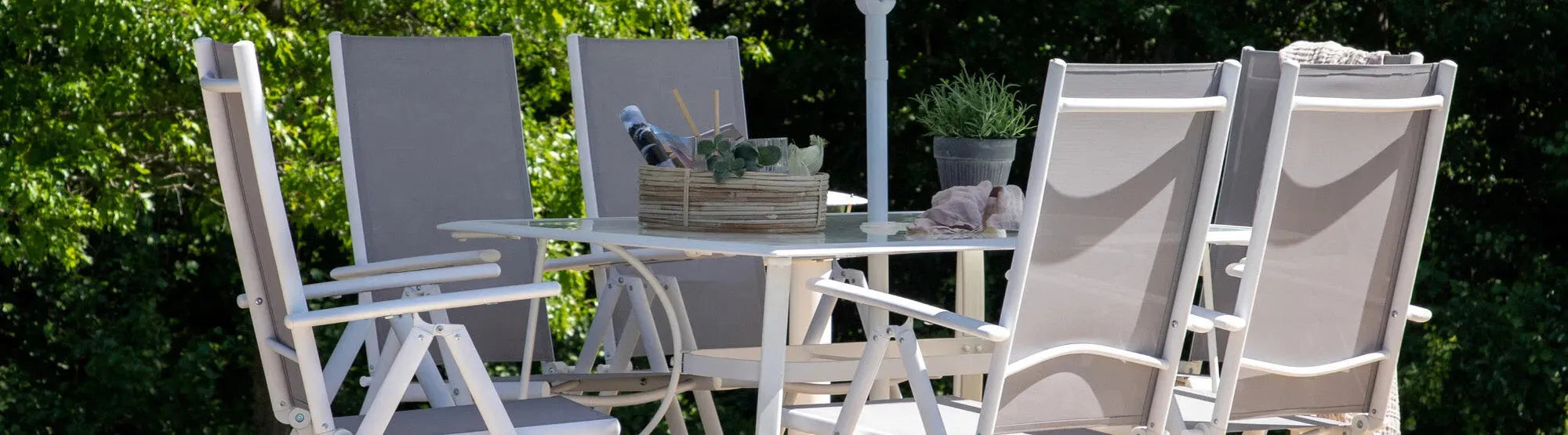 Outdoor-Möbel von Lafuma: Liegestühle, Sessel und Gartentische in modernem Design, auf einer Terrasse in natürlicher Umgebung präsentiert.