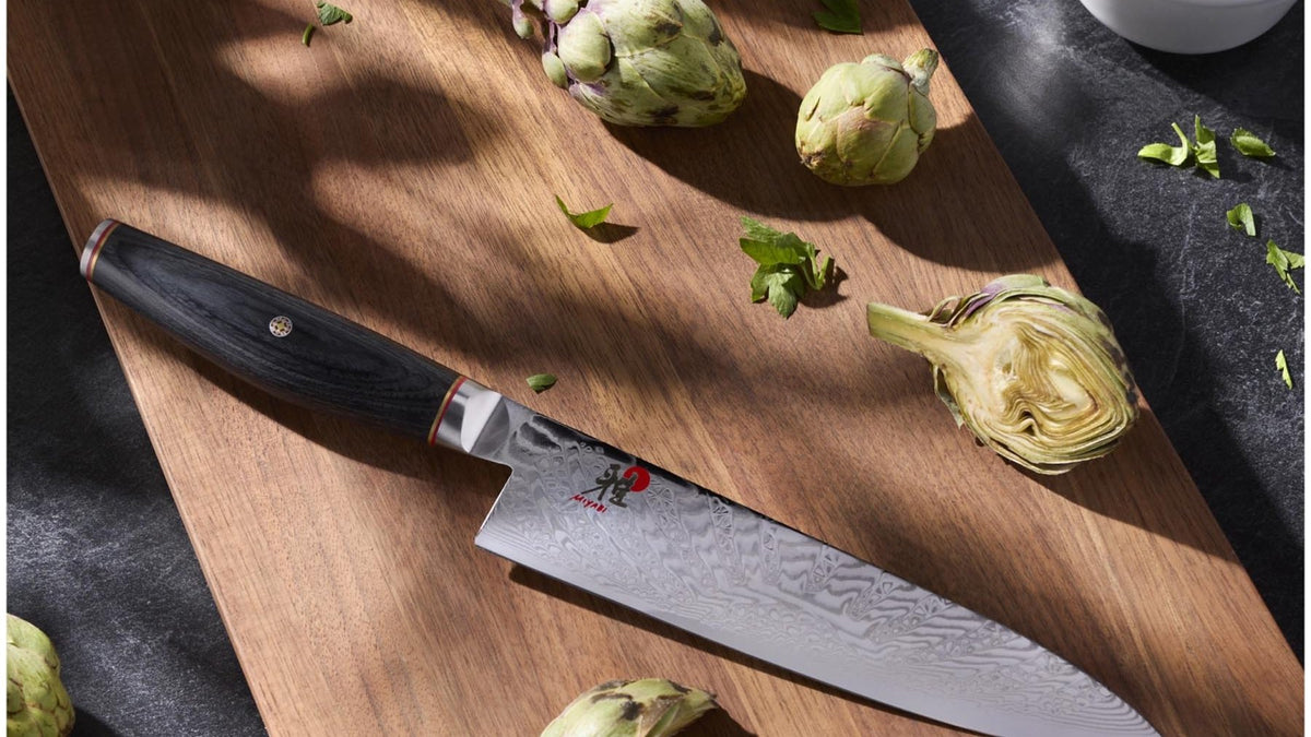 Miyabi Gyutoh Kochmesser mit Damastklinge und ergonomischem Griff auf einem Holzschneidebrett