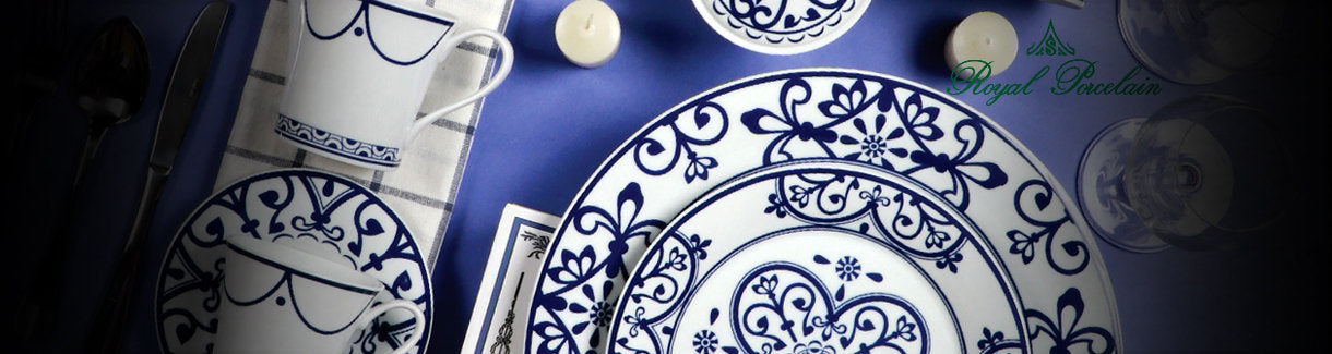 Weisse Porzellanteller und Tassen auf blauem Hintergrundv