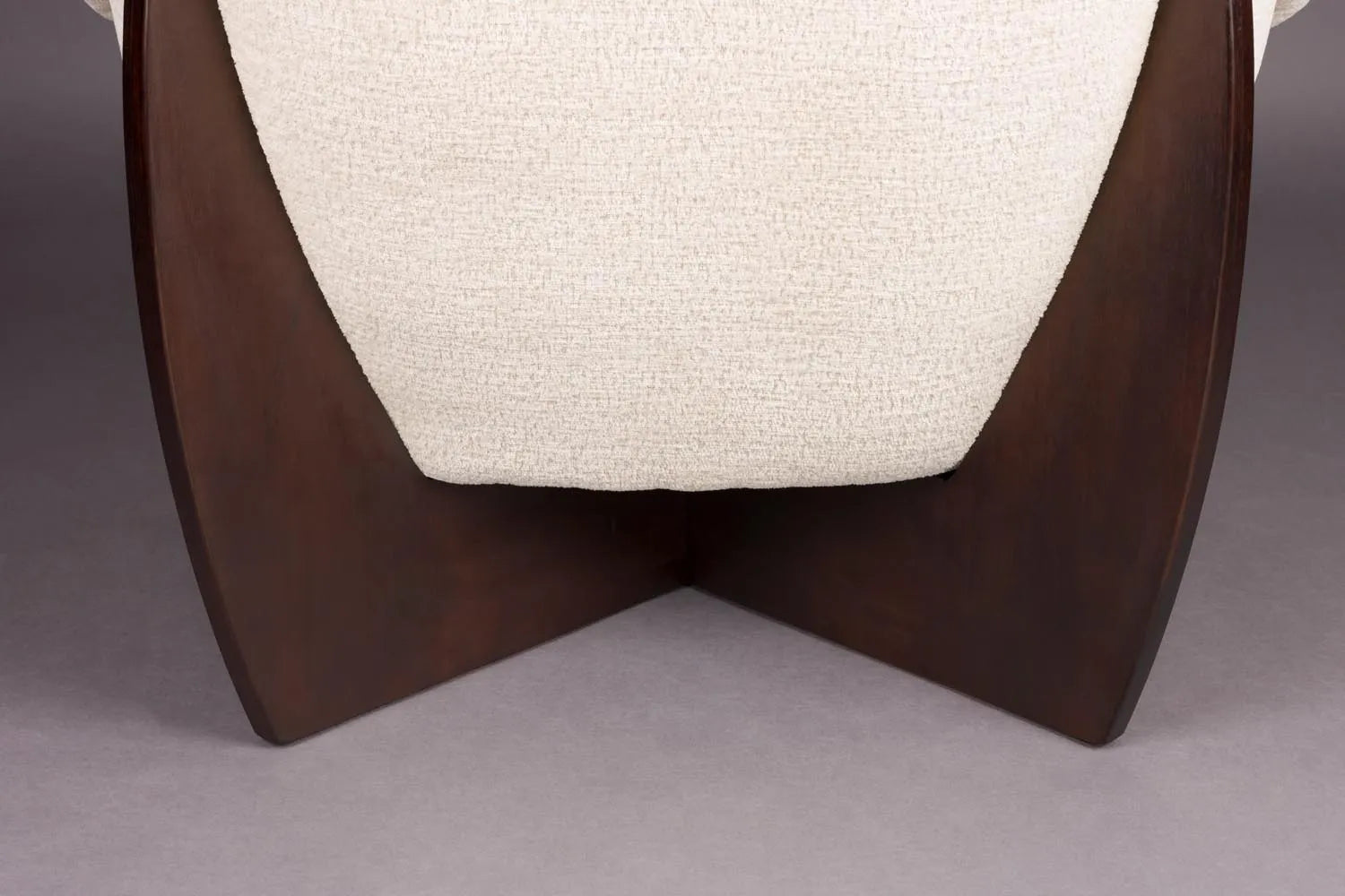 Der Emilius Loungestuhl von Dutchbone vereint luxuriösen Bouclé-Stoff mit elegantem Gummibaumholz für stilvollen Komfort.