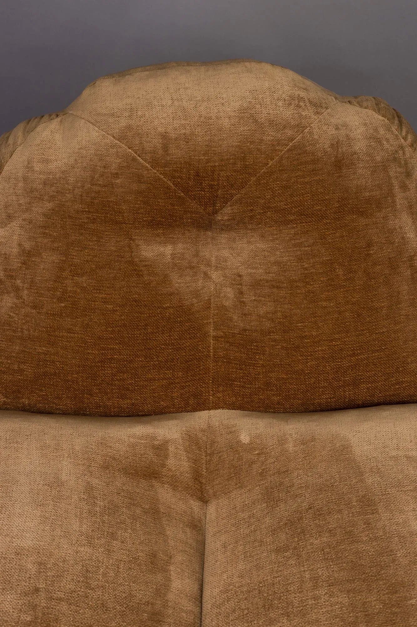 Der Loungesessel Tombag von Dutchbone: Stilvoller Komfort mit samtiger Oberfläche, praktischer Seitentasche und nostalgischem Flair.
