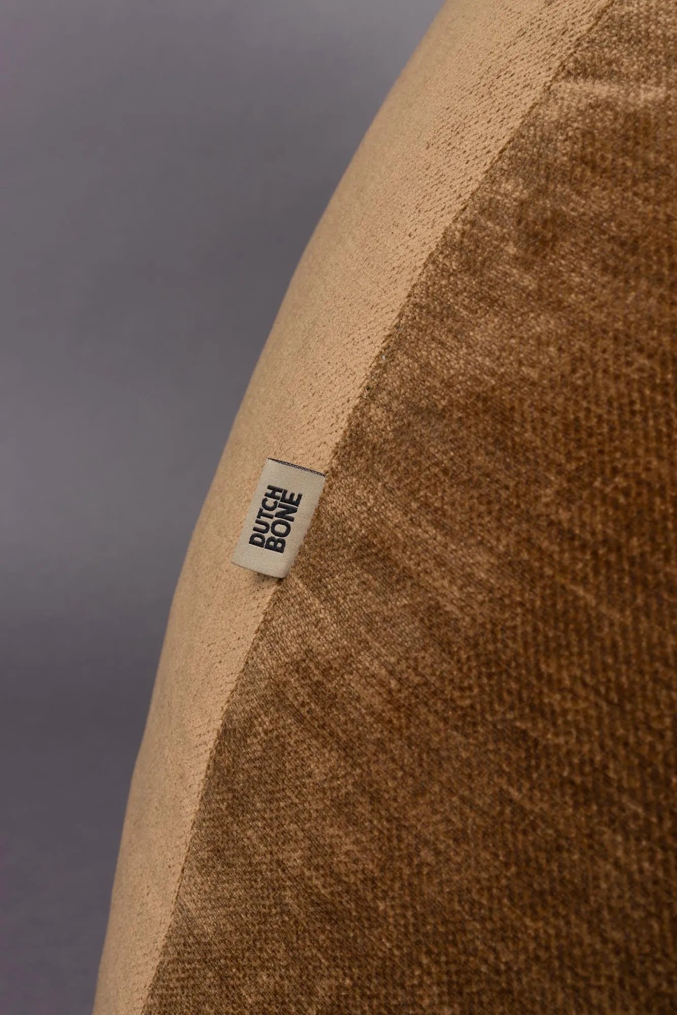 Der Loungesessel Tombag von Dutchbone: Stilvoller Komfort mit samtiger Oberfläche, praktischer Seitentasche und nostalgischem Flair.
