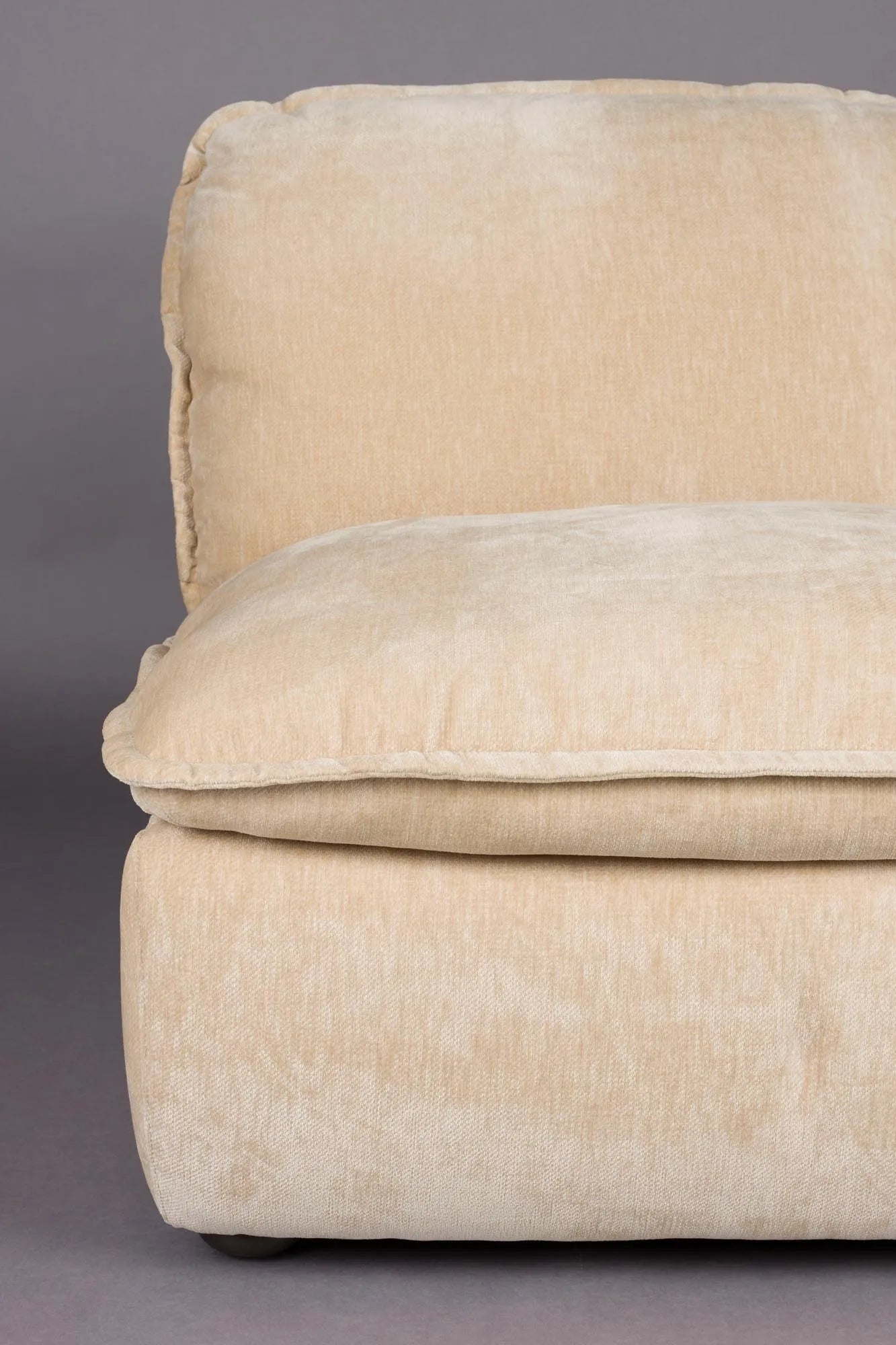 Der Loungesessel Radley von Dutchbone vereint Komfort und Stil mit weichen Kissen und eleganten Holzbeinen für Ihr Zuhause.