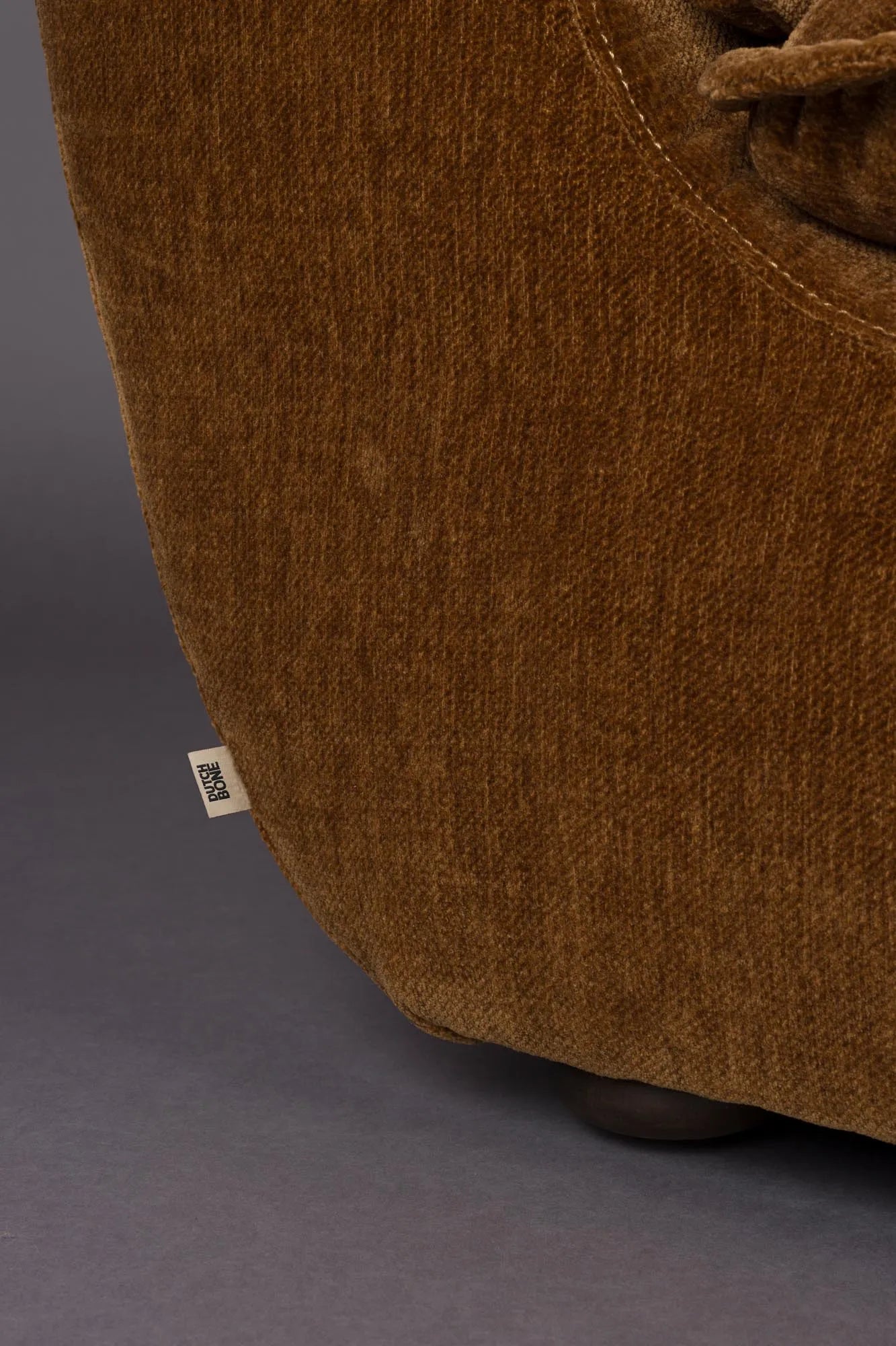 Der Loungesessel Radley von Dutchbone vereint Komfort und Stil mit weichen Kissen und eleganten Holzbeinen für Ihr Zuhause.