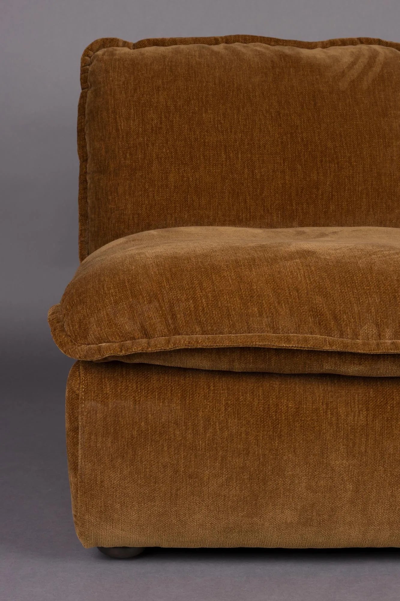 Der Loungesessel Radley von Dutchbone vereint Komfort und Stil mit weichen Kissen und eleganten Holzbeinen für Ihr Zuhause.