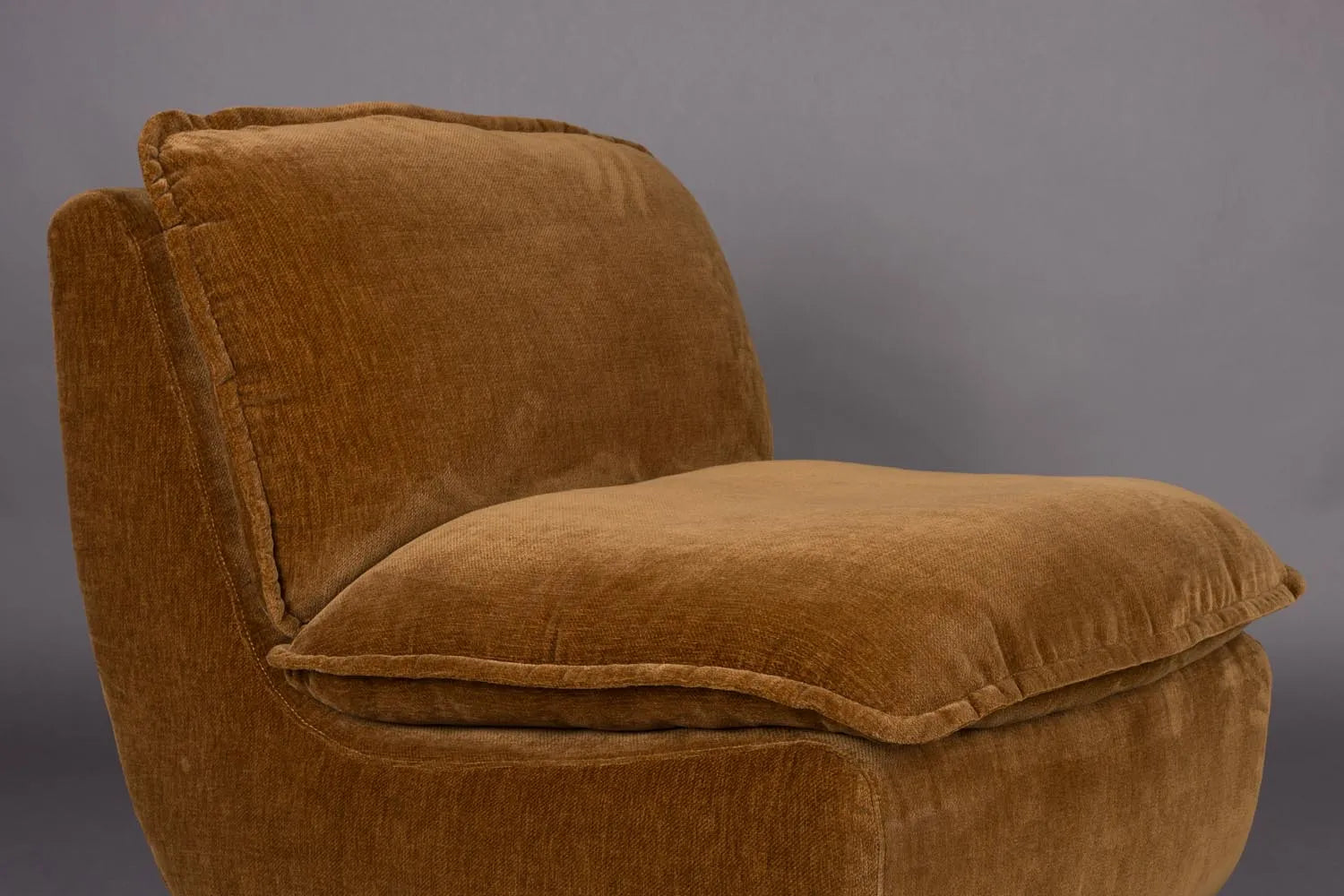 Der Loungesessel Radley von Dutchbone vereint Komfort und Stil mit weichen Kissen und eleganten Holzbeinen für Ihr Zuhause.