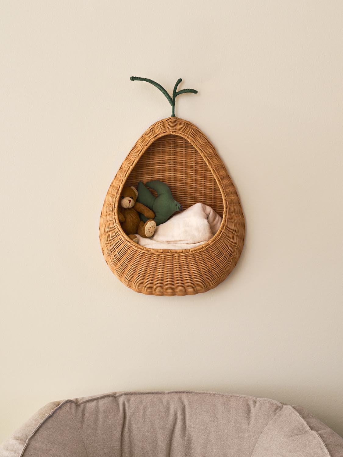 Birnenförmige Wandtasche aus geflochtenem Rattan in Natural mit grünem Blatt-Detail und Innenstruktur aus Eisen, für Kinderzimmer.