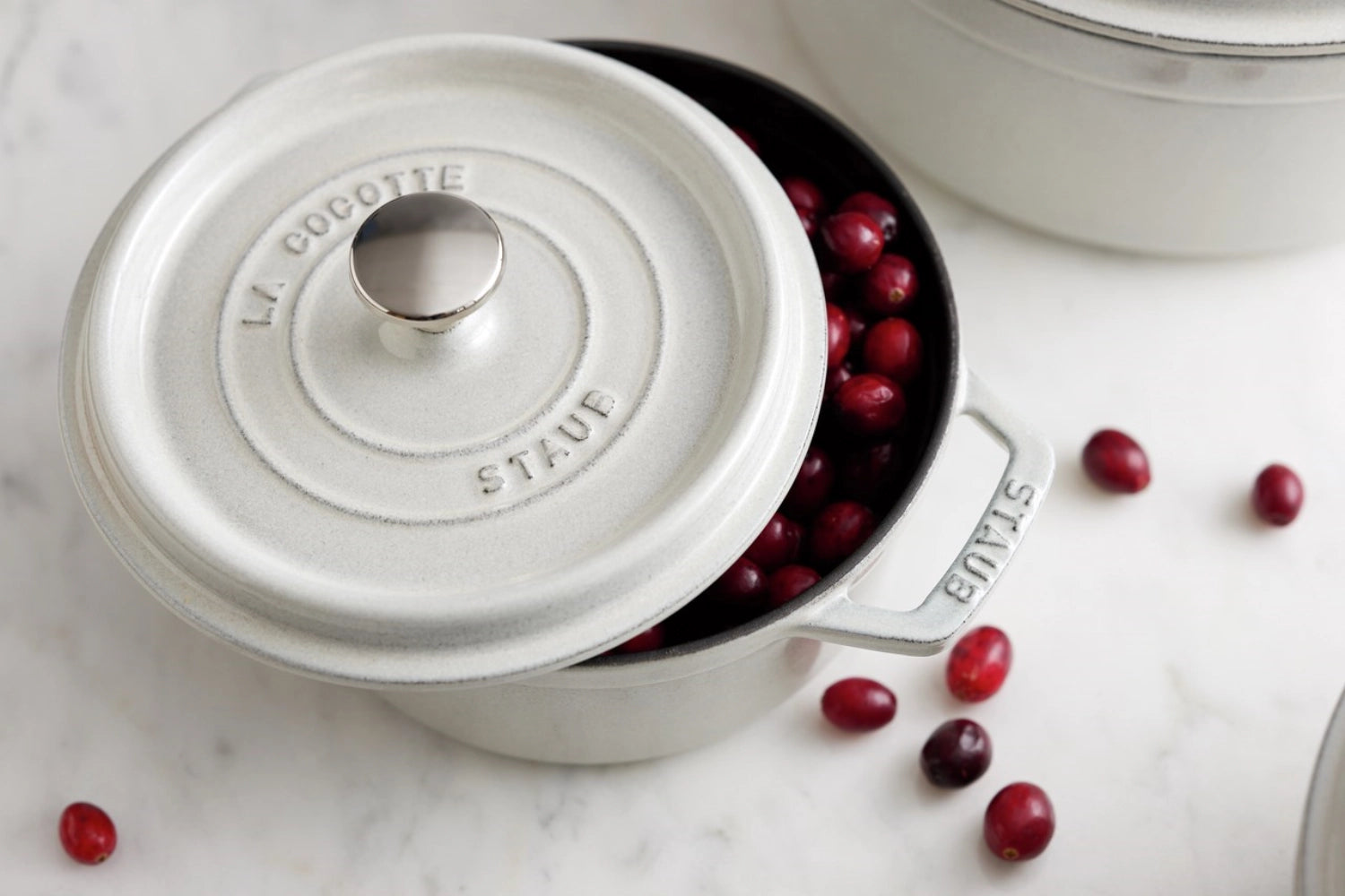 Runde Cocotte von Staub, 20 cm, aus hochwertigem Gusseisen, in edlem Weiß mit Trüffel-Finish, ideal für stilvolles Kochen und Servieren.