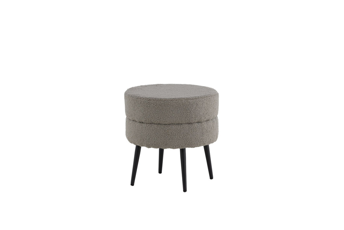 Runder Pouf Pot in Grau mit Teddystoff-Bezug, Durchmesser 40 cm, auf schwarzen, leicht ausgestellten Stahlbeinen stehend.