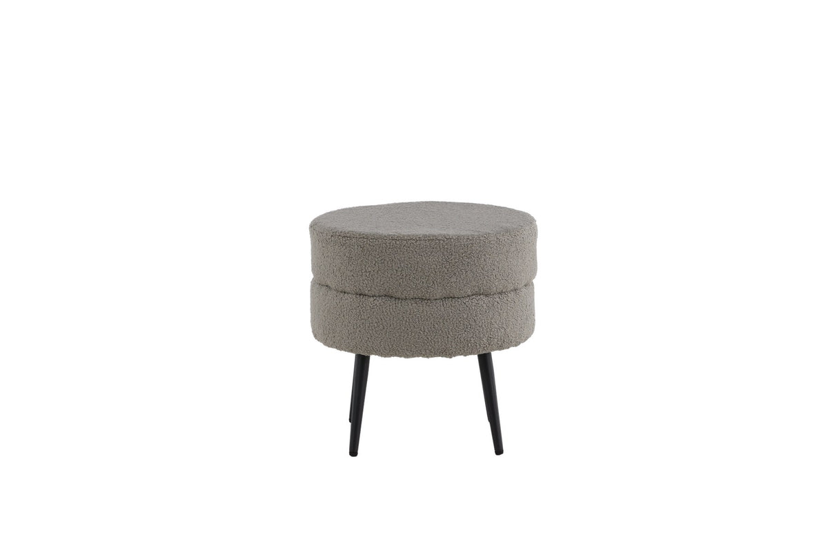 Runder Pouf Pot in Grau mit Teddystoff-Bezug, Durchmesser 40 cm, auf schwarzen, leicht ausgestellten Stahlbeinen stehend.