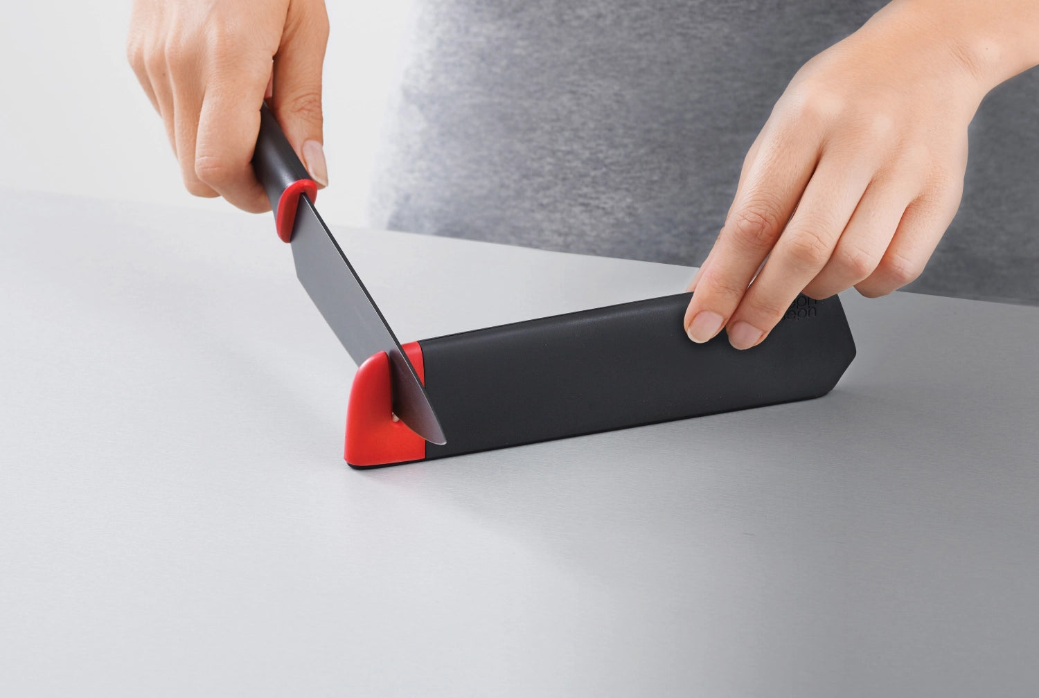 Modernes 2er Messerset von Joseph Joseph: Rüst- und Kochmesser mit integriertem Schärfer, in stilvollem Rot und Grau.