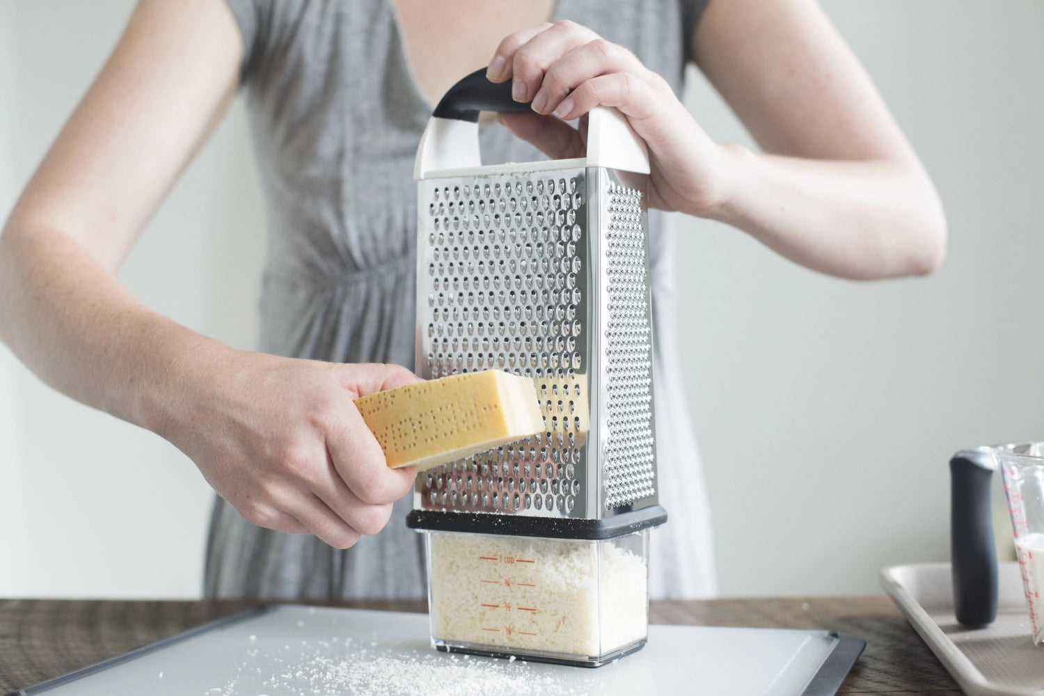 Praktische 4-seitige Reibe von OXO mit integriertem Auffangbehälter, ideal zum einfachen Zerkleinern und Reiben von Lebensmitteln.