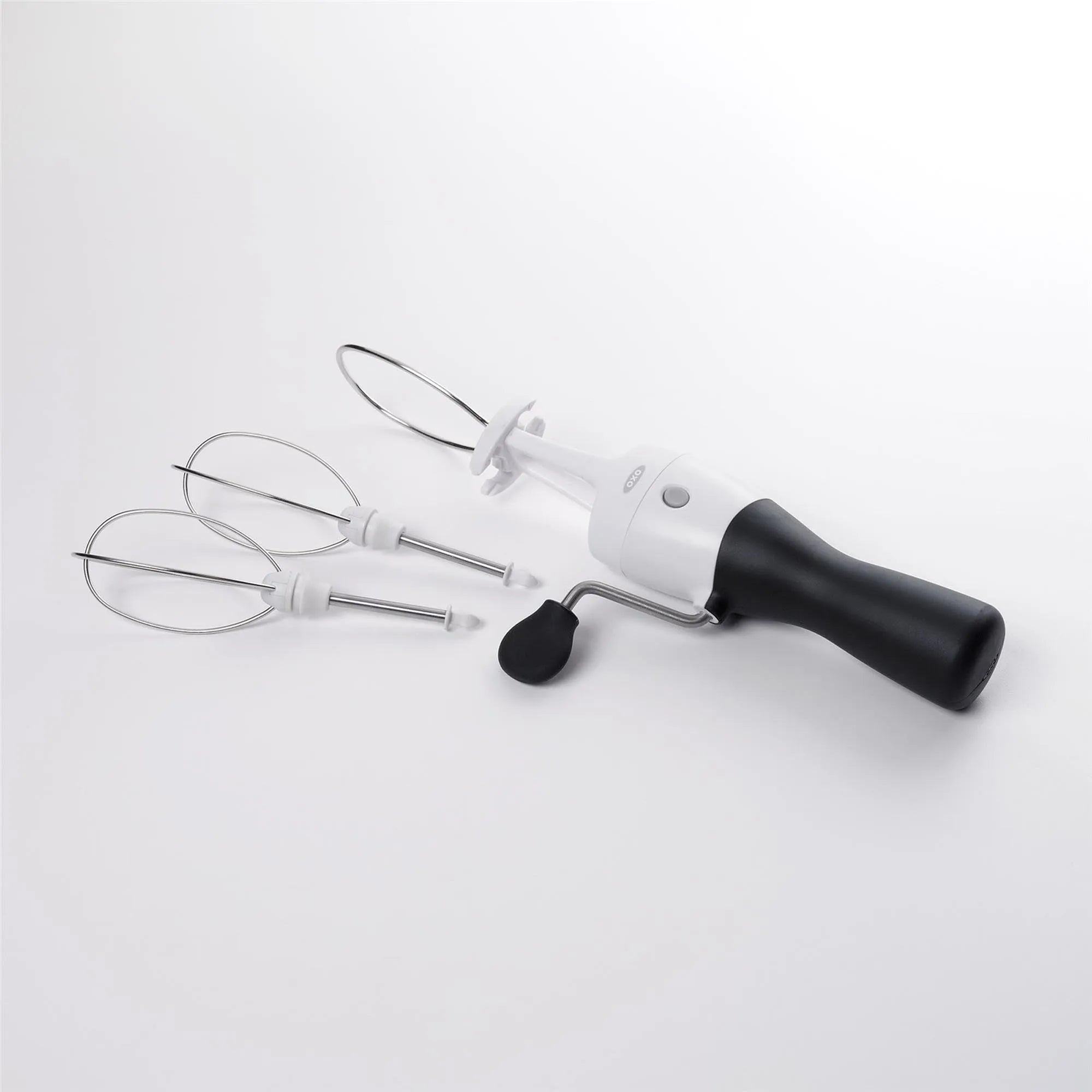 Eleganter OXO Handrührer, weiß, mit starkem Motor, ergonomischem Griff und Edelstahlbesen für müheloses Backen.