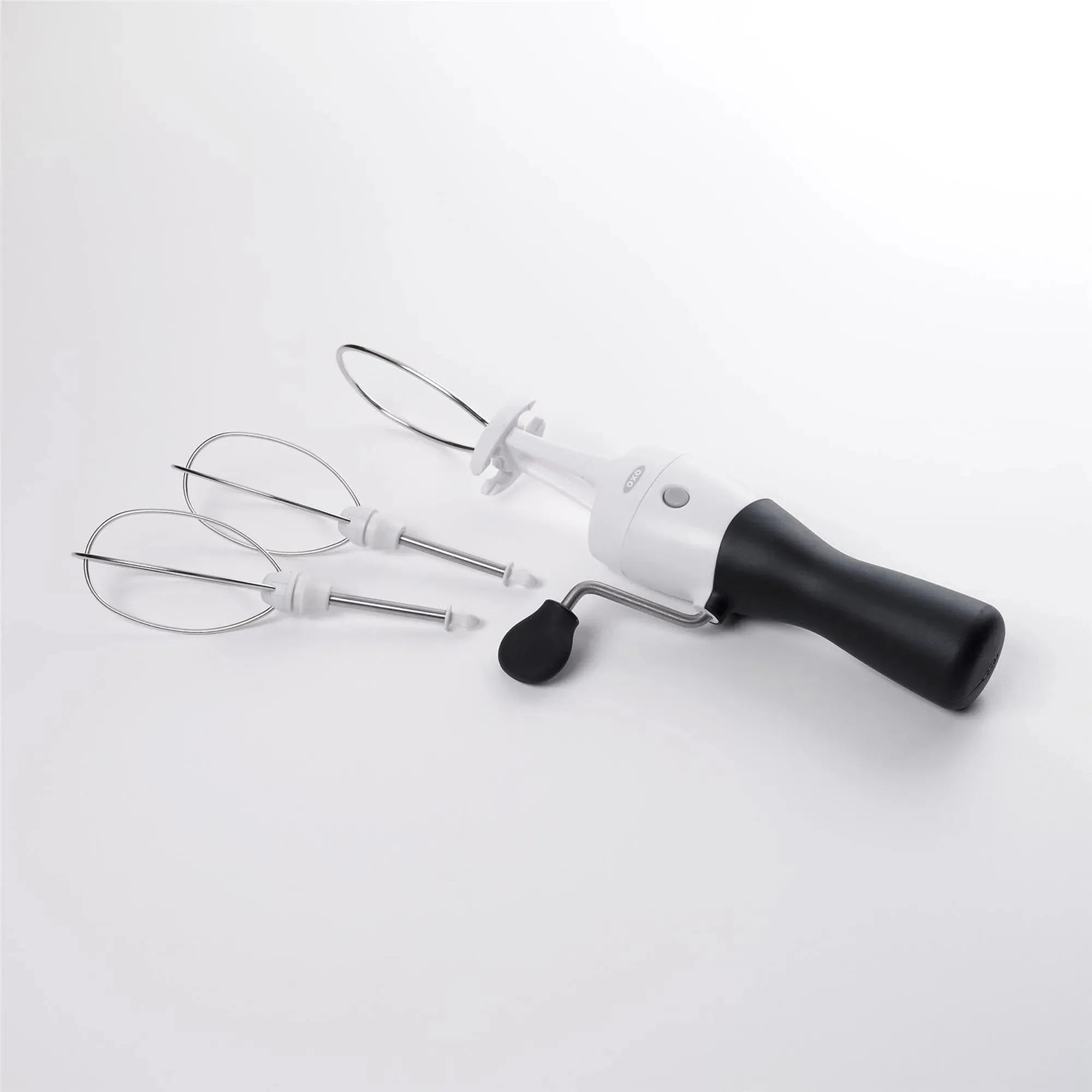 Eleganter OXO Handrührer, weiß, mit starkem Motor, ergonomischem Griff und Edelstahlbesen für müheloses Backen.