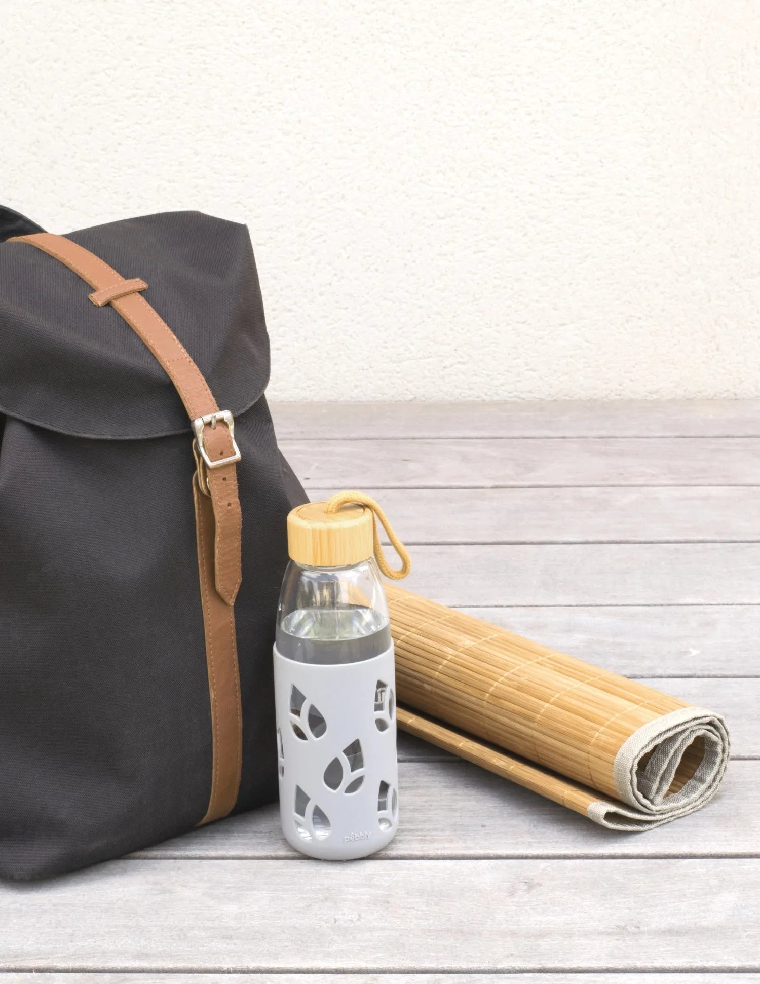 Nachhaltige 55cl Glasflasche mit Bambusdeckel und beigem Silikonüberzug.