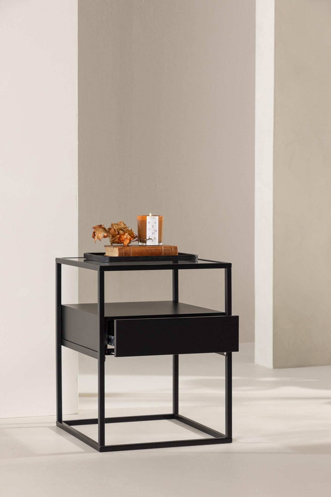 Der Fortaleza Beistelltisch von Venture Home vereint stilvolles Design mit Funktionalität. Robuster Stahl, elegante Glasplatte, praktische Schublade und offene Regale machen ihn zum idealen Möbelstück für jeden Raum.