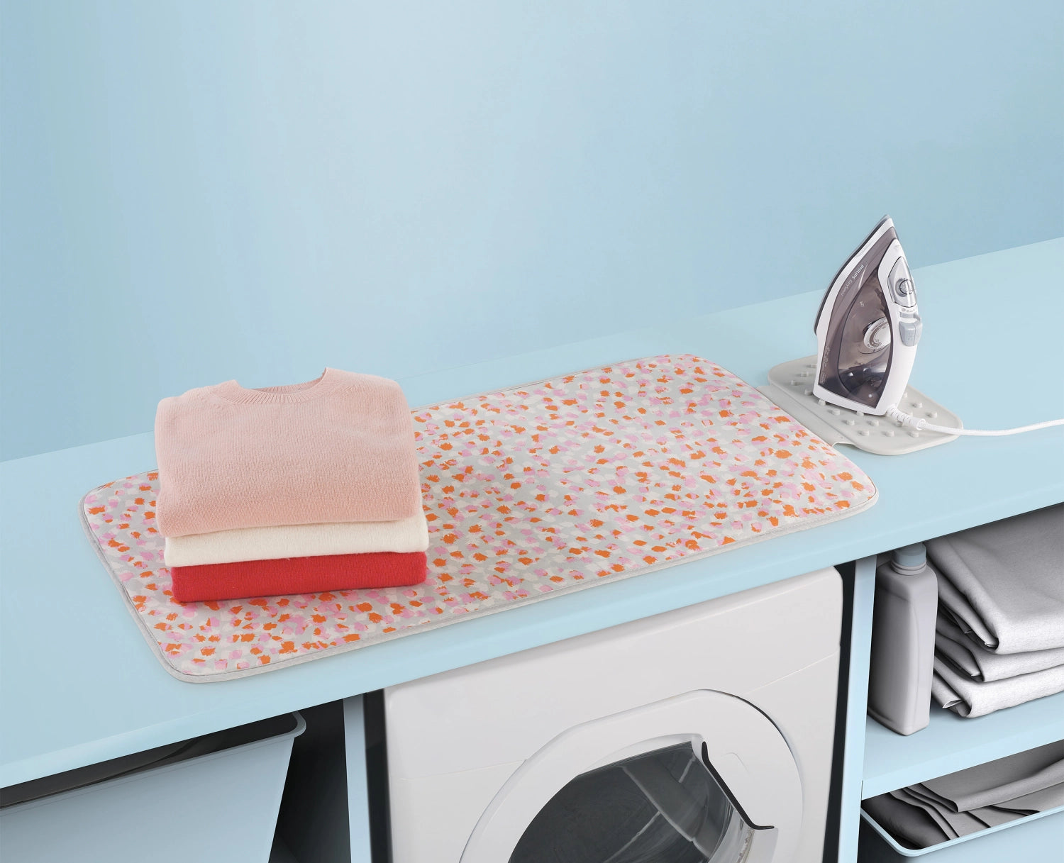 Praktische und elegante Bügelmatte in zartem Peach Blossom, ideal für effizientes Bügeln und platzsparende Aufbewahrung.