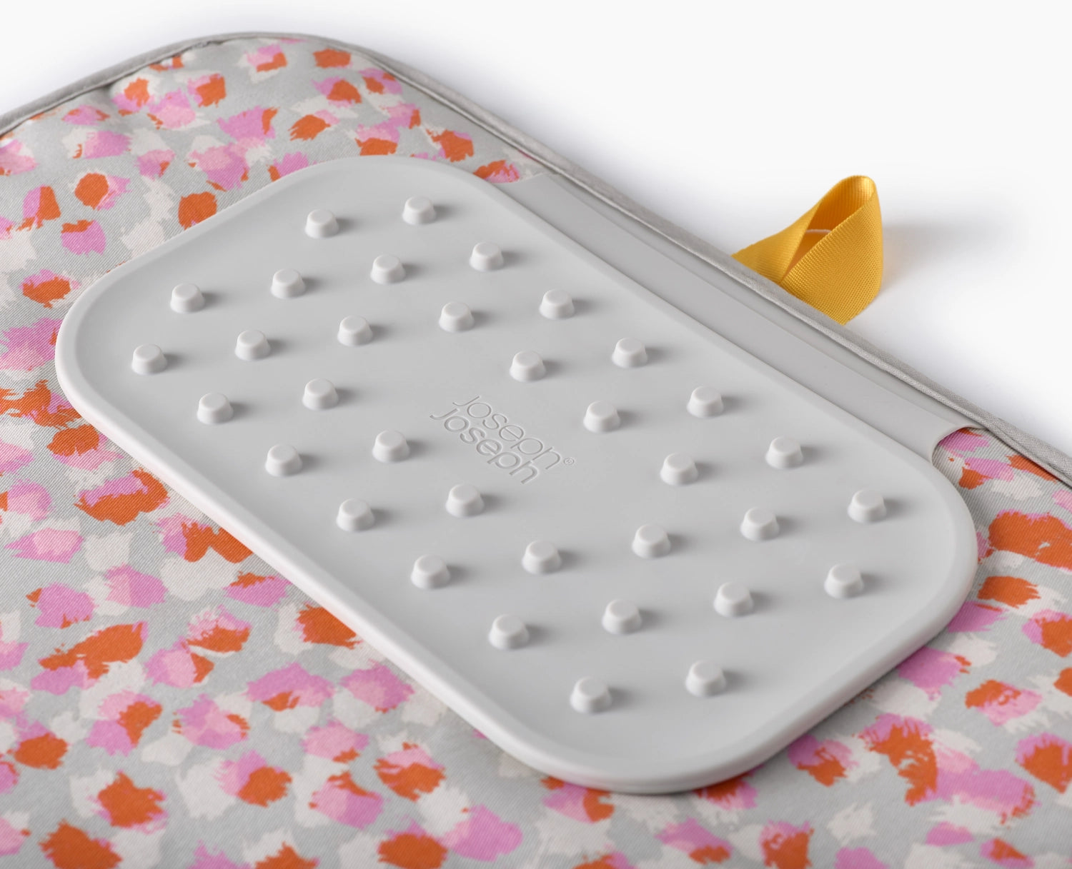 Praktische und stilvolle Bügelmatte in zartem Peach Blossom, ideal für platzsparendes Bügeln und mühelose Aufbewahrung.