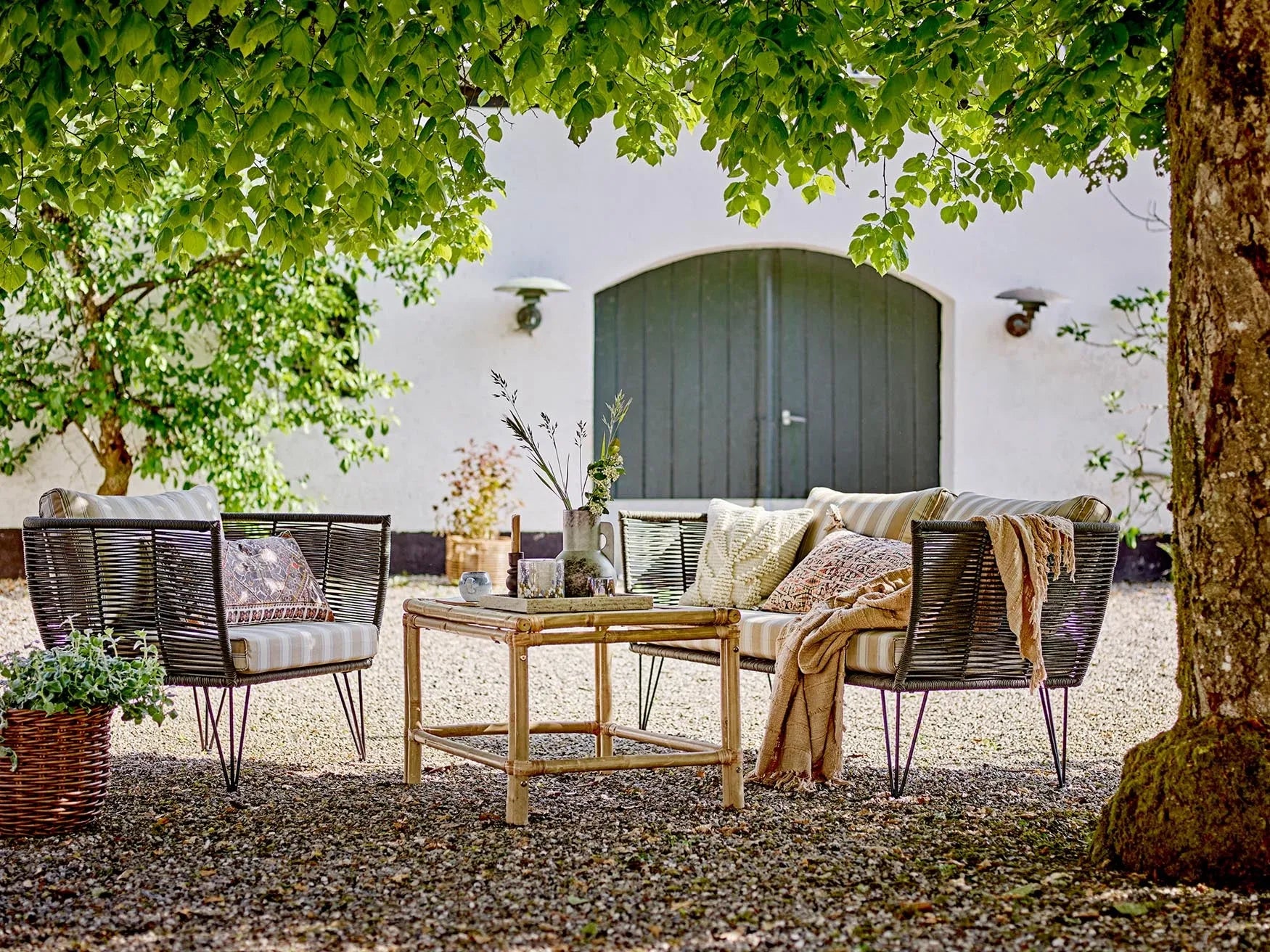 Eleganter Loungesessel aus schwarzem Metall mit handgewebtem Polyesterseil und waschbaren sandfarbenen Polstern.