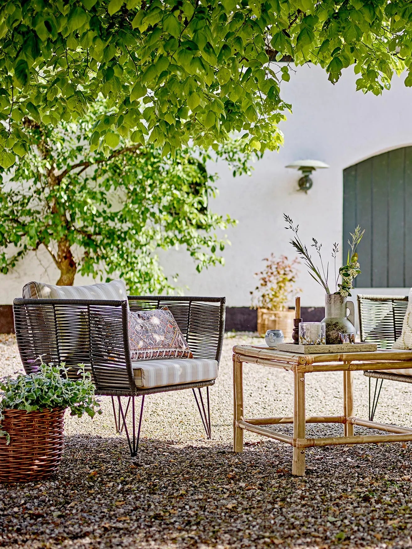 Eleganter Loungesessel aus schwarzem Metall mit handgewebtem Polyesterseil und waschbaren sandfarbenen Polstern.