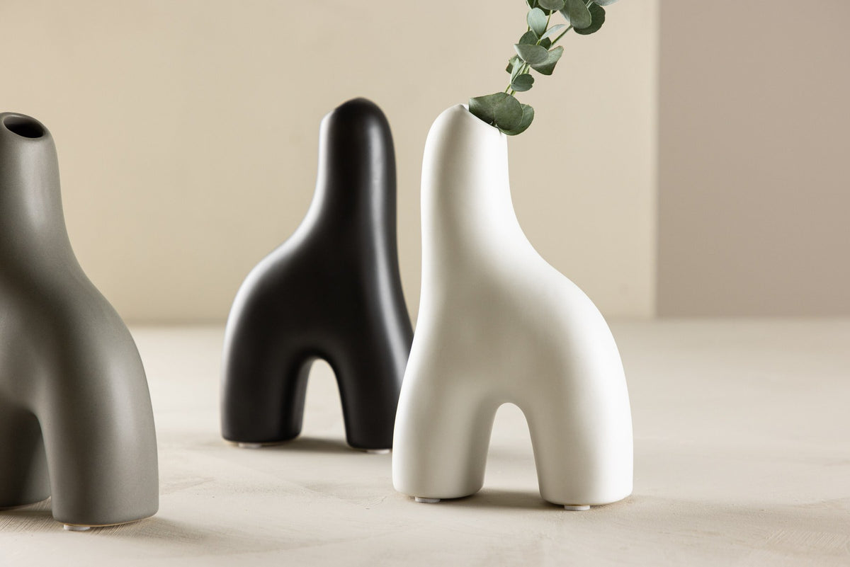 Weisse Vase Aya von Venture Home aus Steinzeug mit schlanker, eigenwilliger Form, freigestellt fotografiert.