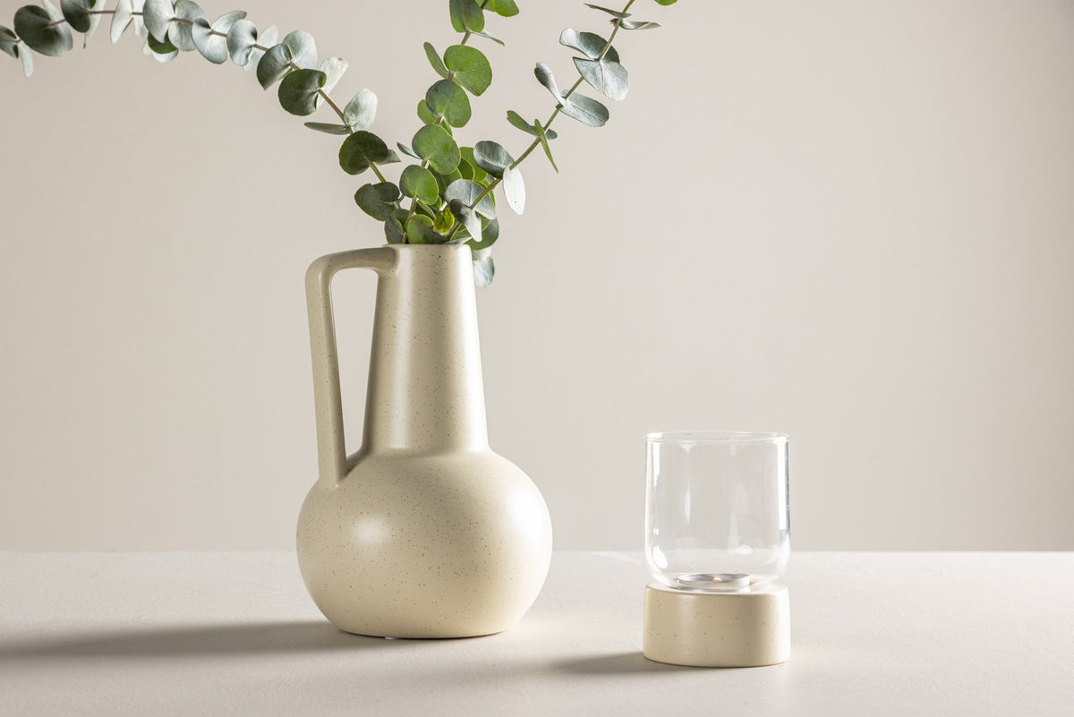 Zylindrische Vase aus Steinzeug in Beige und Schwarz mit seitlichem Griff, matte Oberfläche, Höhe 22 cm, Durchmesser 10 cm.