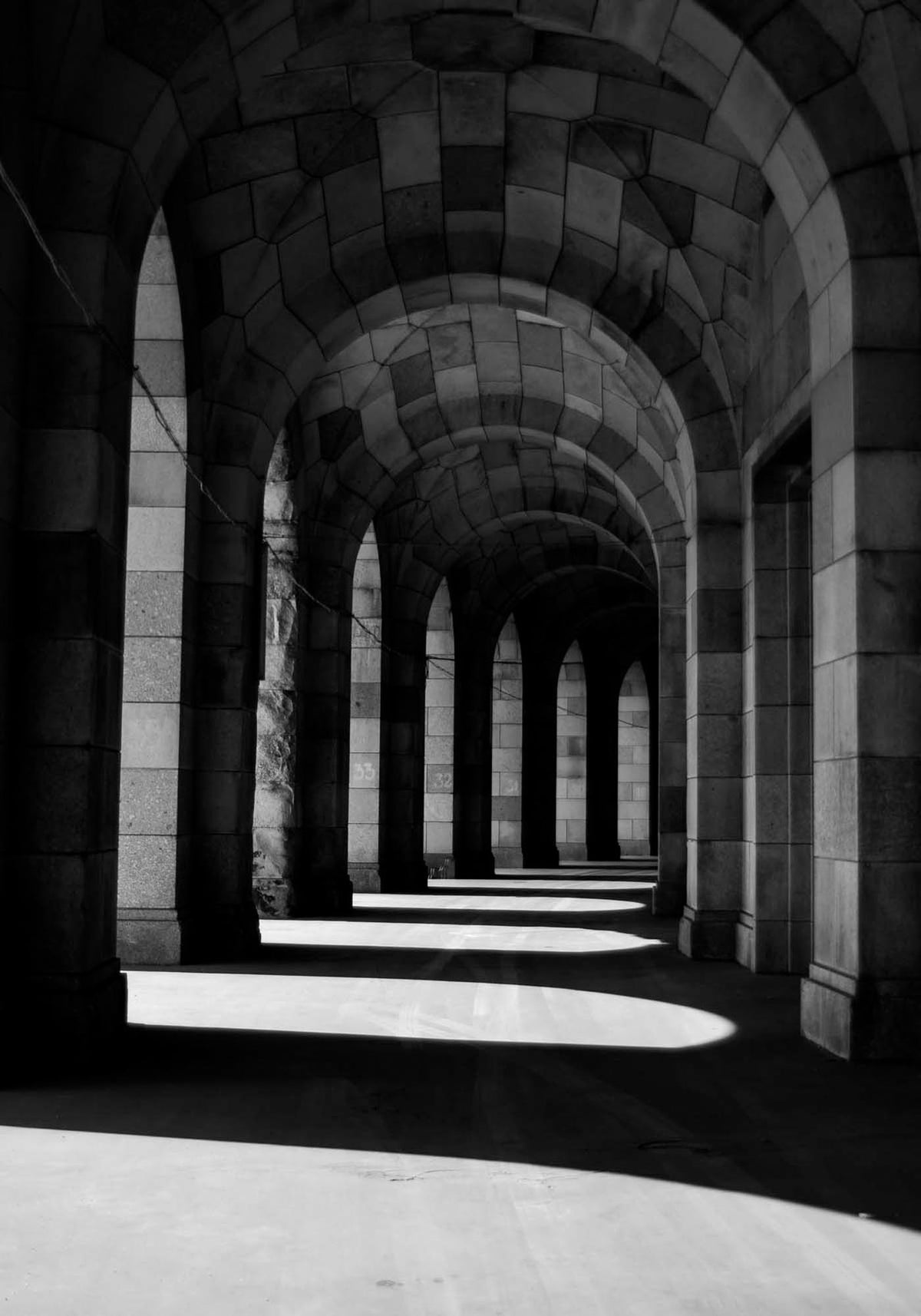 Beiges Walkway Poster aus Papier mit Schwarz-Weiss-Fotomotiv, kontrastreiche Formen in symmetrischer Komposition an der Wand.