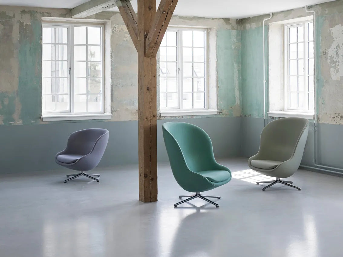 Hochwertiger Hyg Lounge Drehsessel mit hoher Rückenlehne, bezogen mit weichem Bouclé-Stoff, ausgestattet mit Dreh- und Kippfunktion, modernes skandinavisches Design, präsentiert als Ausstellungsstück in neutralen Farbtönen.
