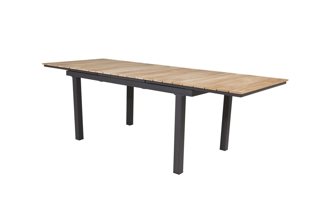 Rechteckiger Gartentisch Mexiko mit naturfarbener Teakholz-Tischplatte und schwarzem Aluminiumgestell, ausziehbar, im Freien aufgestellt.