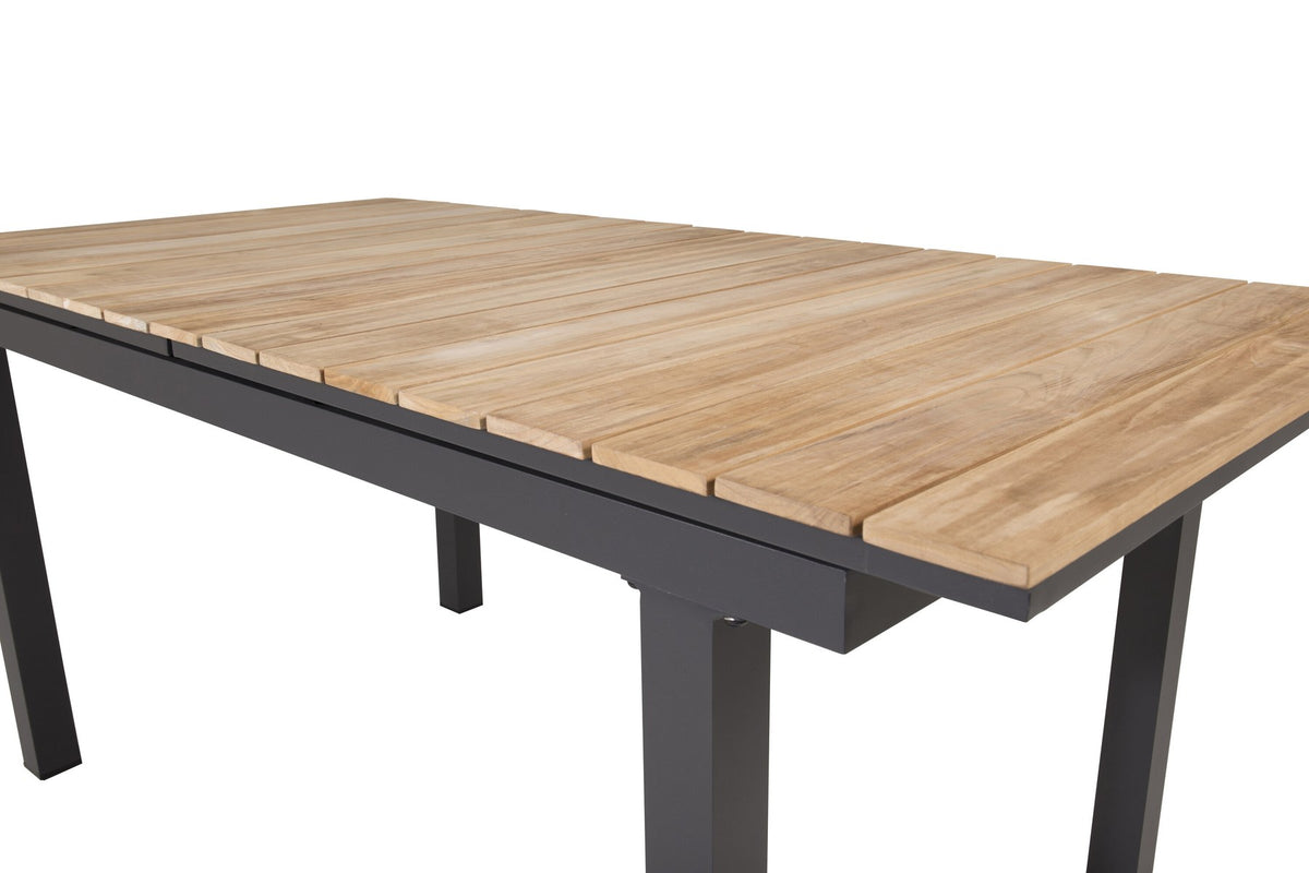 Rechteckiger Gartentisch Mexiko mit naturfarbener Teakholz-Tischplatte und schwarzem Aluminiumgestell, ausziehbar, im Freien aufgestellt.