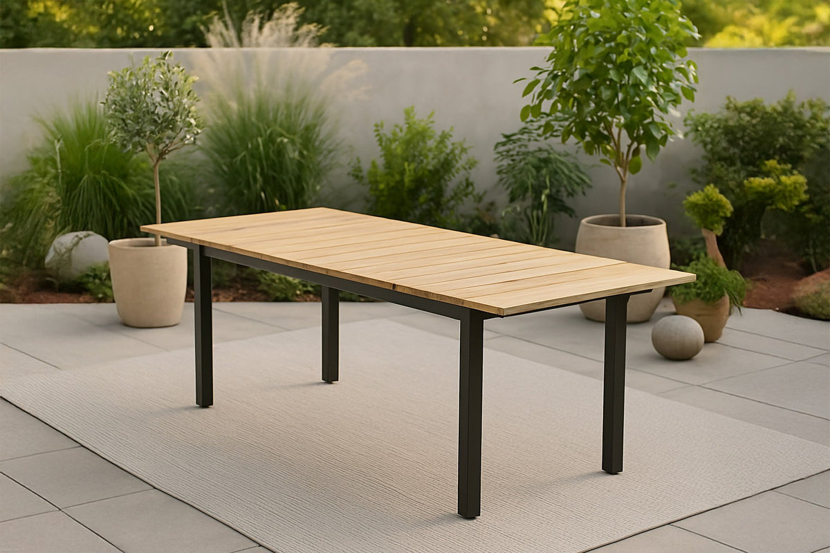 Rechteckiger Gartentisch Mexiko mit naturfarbener Teakholz-Tischplatte und schwarzem Aluminiumgestell, ausziehbar, im Freien aufgestellt.