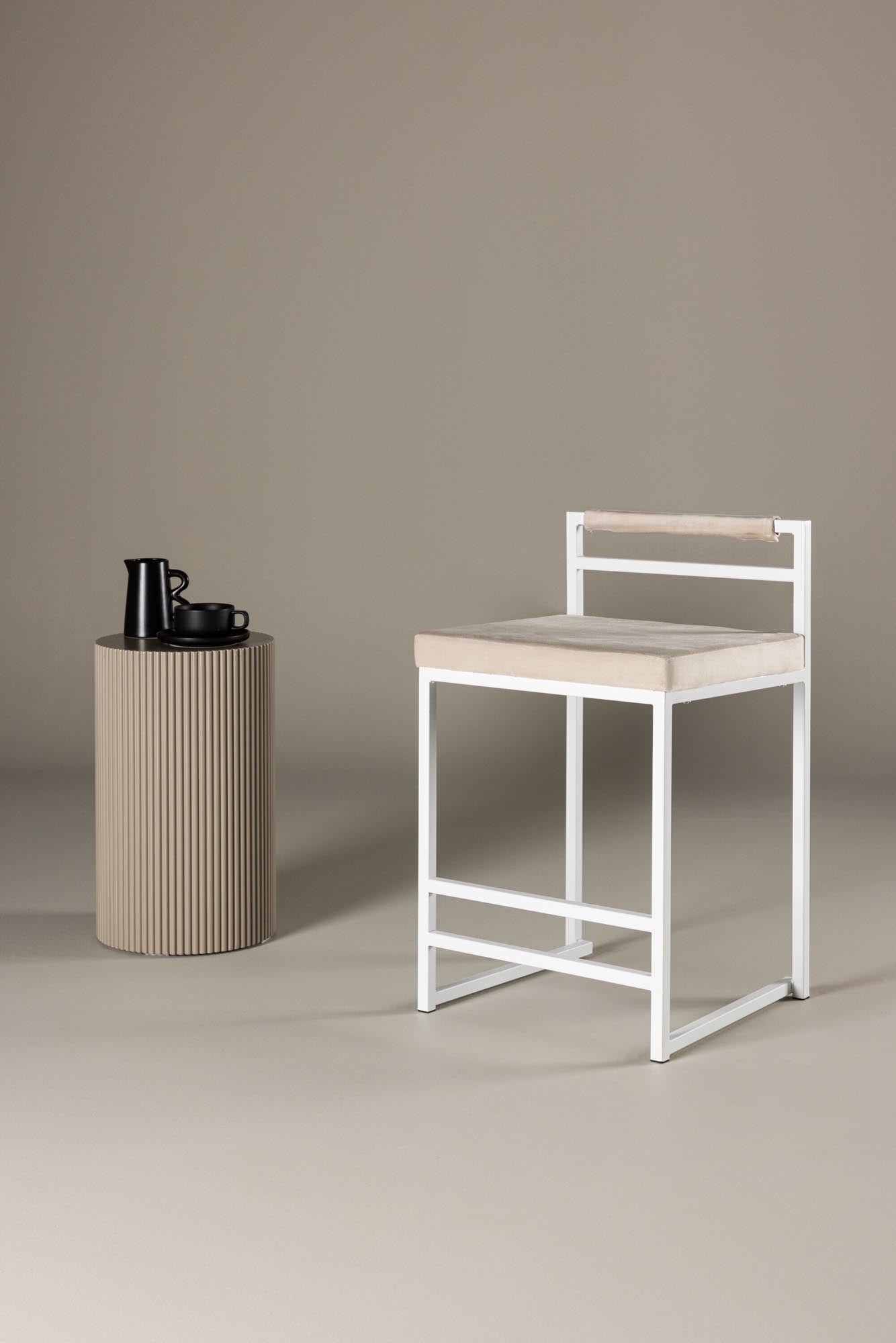 Eleganter Barhocker mit beigem Samtbezug und weißen Stahlbeinen, ideal für stilvolle Wohnräume.