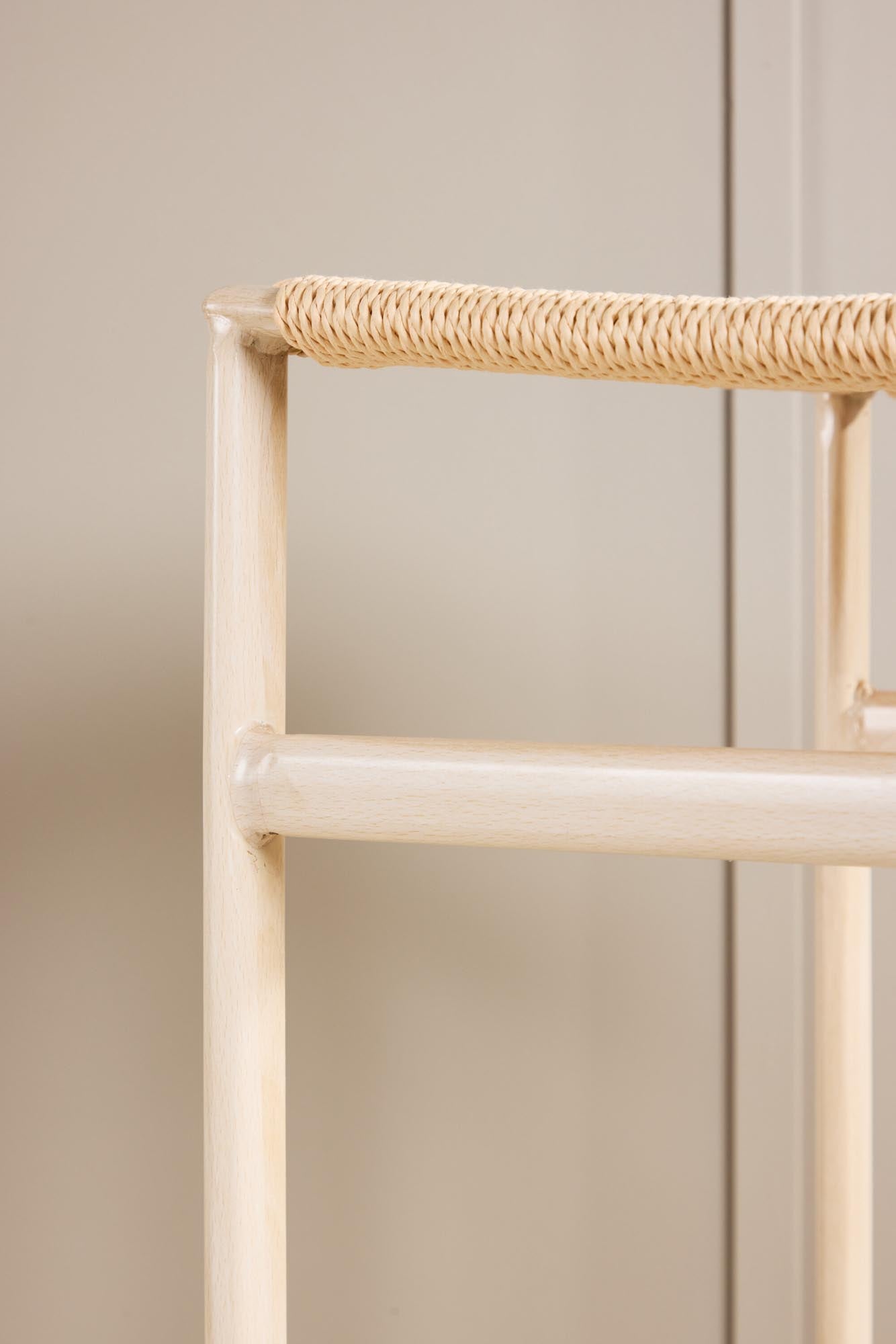 Der Polly Barstuhl vereint Rattan-Sitz und weiße Holzbeine zu einem stilvollen, platzsparenden Design für modernen Boho-Chic.