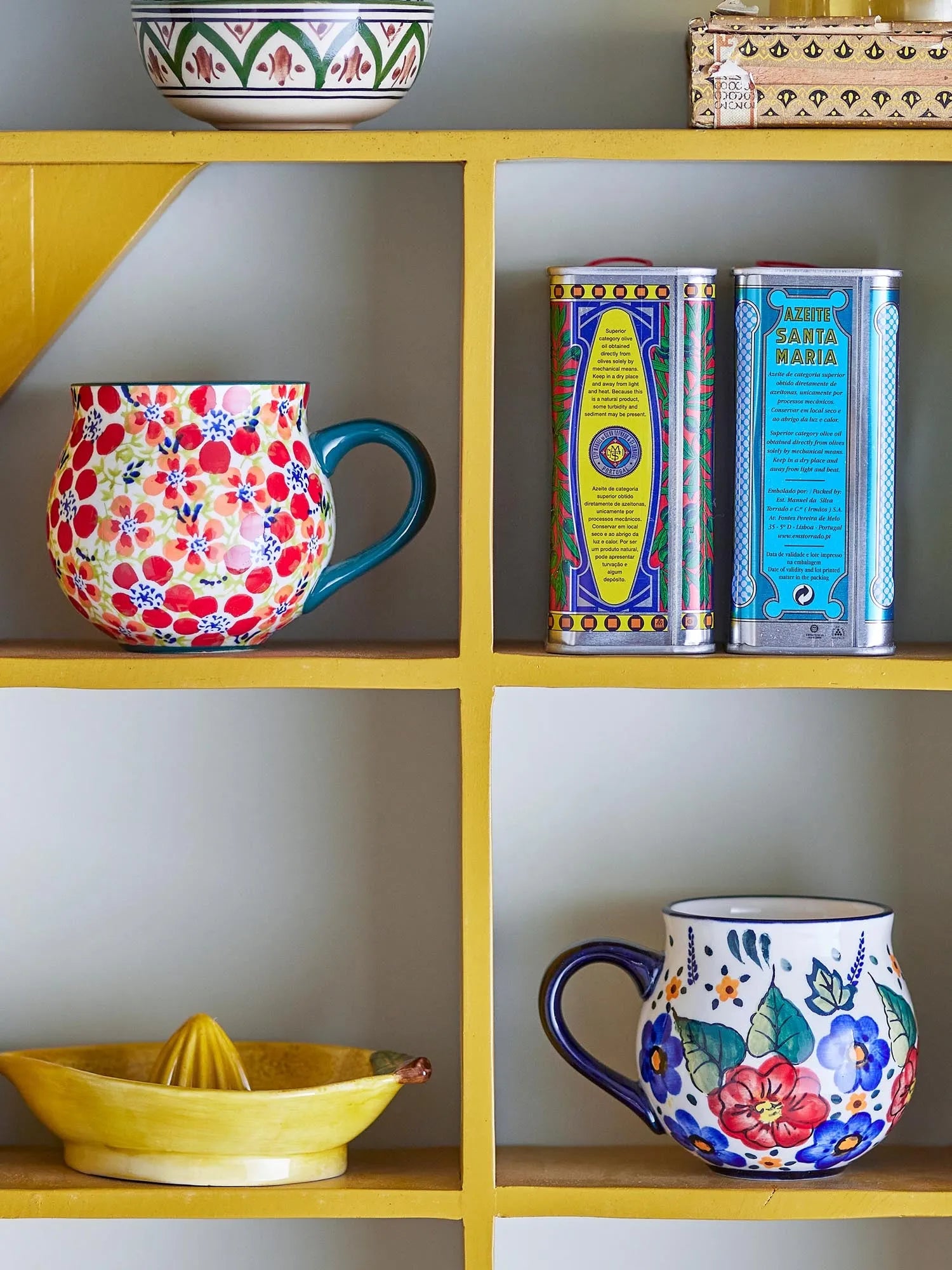Elegante rote Steingut-Tasse mit handgemalten Blumenmotiven, spülmaschinen- und mikrowellengeeignet.