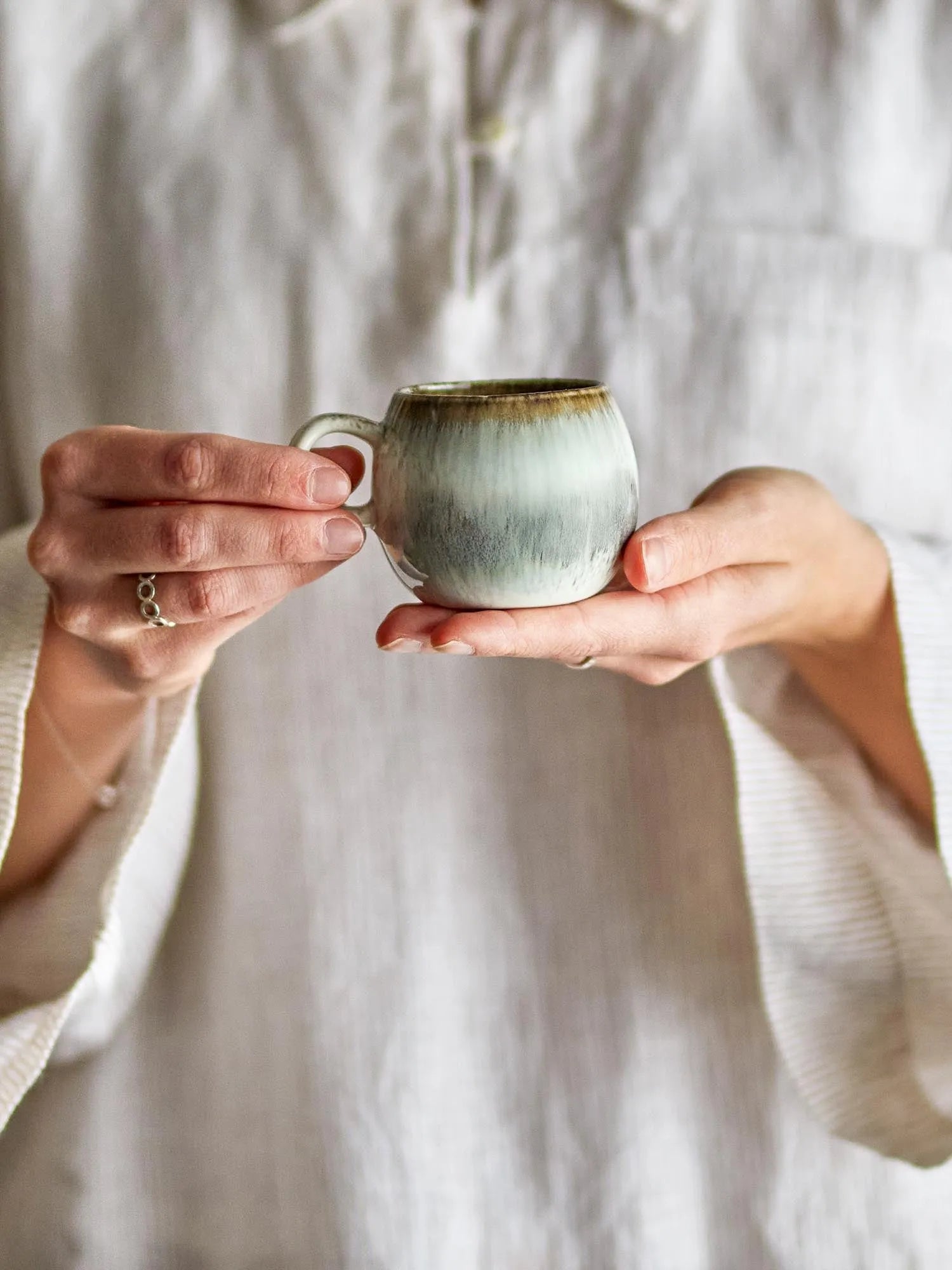 Elegante Espressotasse aus grauem Steingut mit einzigartiger Glasur, die Wärme speichert und stilvoll in der Hand liegt.